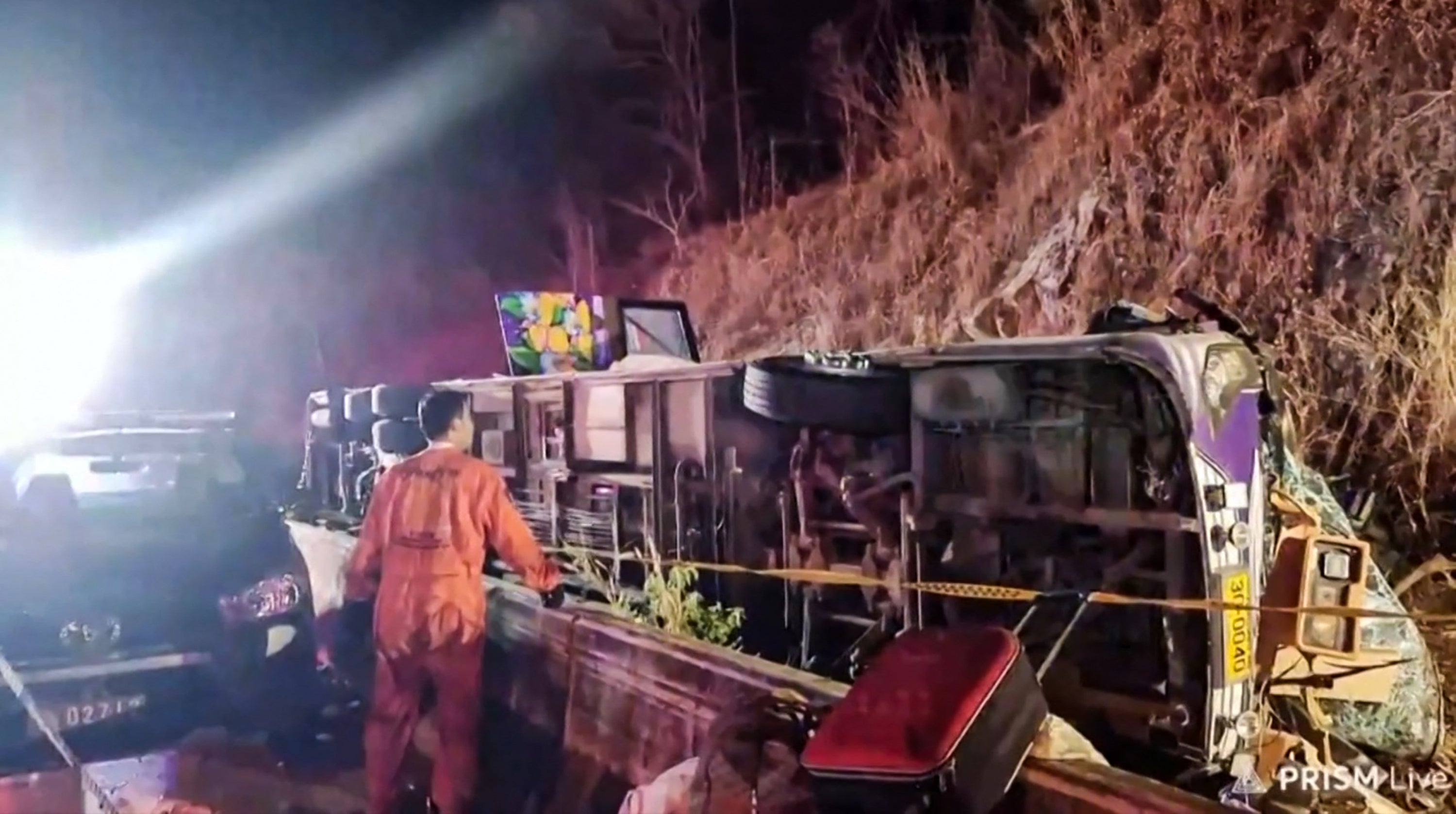 This frame grab taken from video footage provided by local Facebook group 'Sue Prachinburi' on February 26, 2025 via AFPTV shows a rescue worker at the site of a bus crash that killed 18 people in Prachinburi province