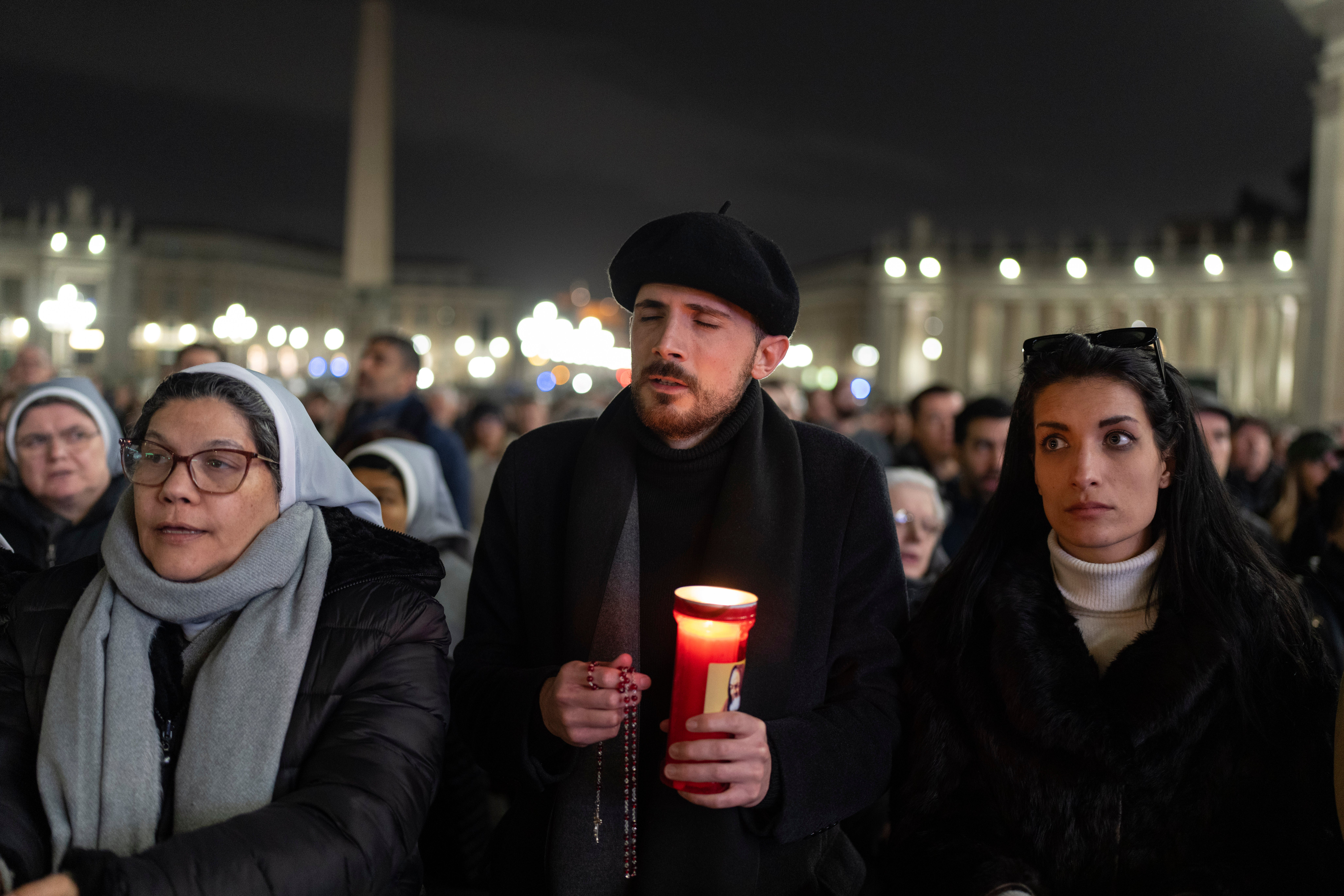 Catholic faithful attend a nightly rosary prayer service for the health of Pope Francis in St Peter's Square at the Vatican