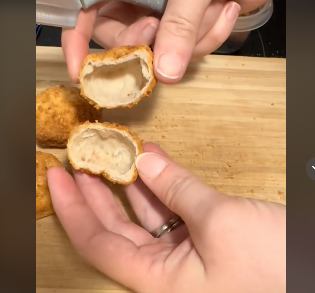 A TikTok user shows what they claim to be empty Great Value chicken nuggets that they bought from Walmart. The nuggets actually do have meat inside, but the interior is hollow.