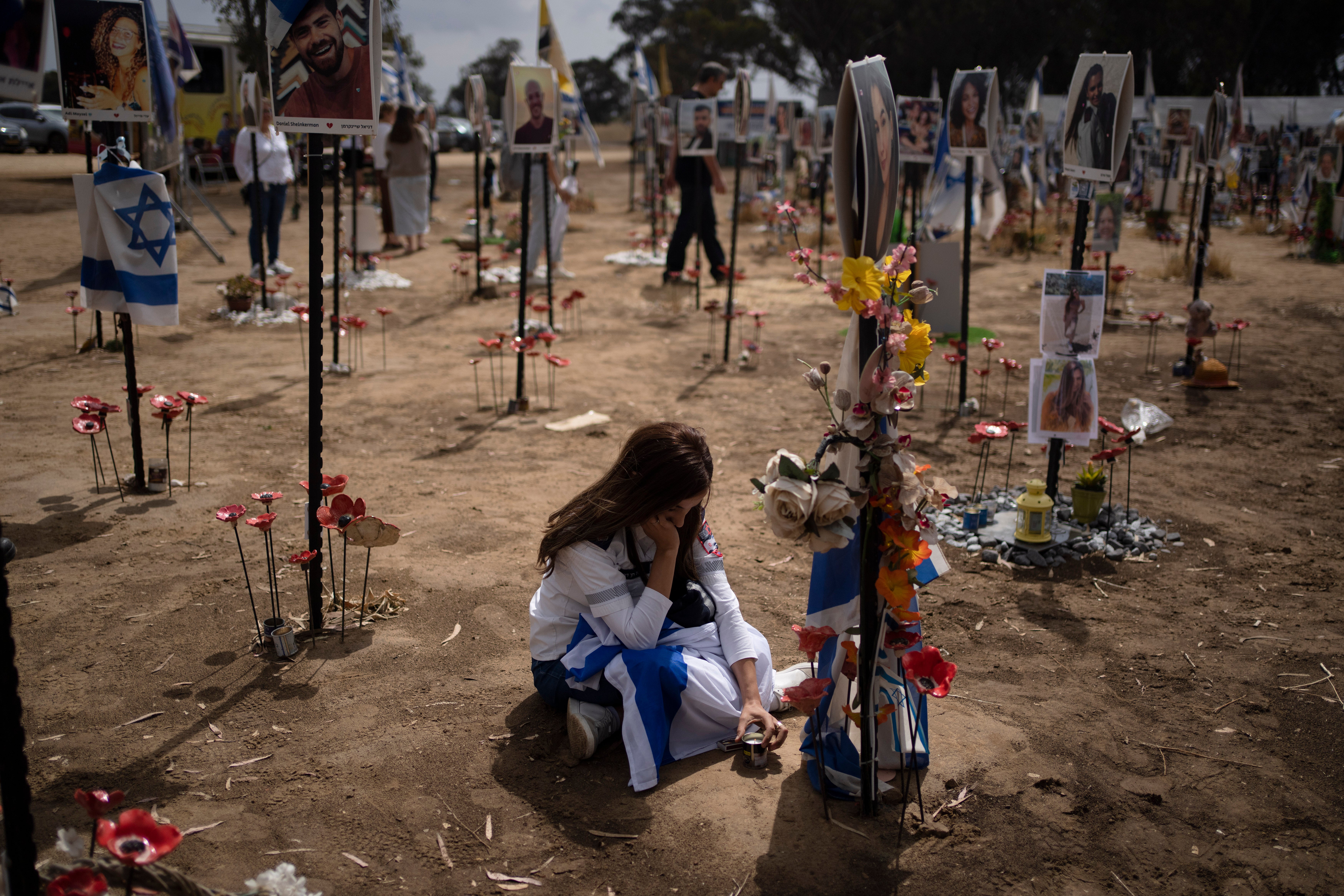 File: A woman grieves at a memorial for those killed and abducted during the 7 Oct 2023, cross-border attack by Hamas militants, near the kibbutz Reim, southern Israel, 13 May 2024