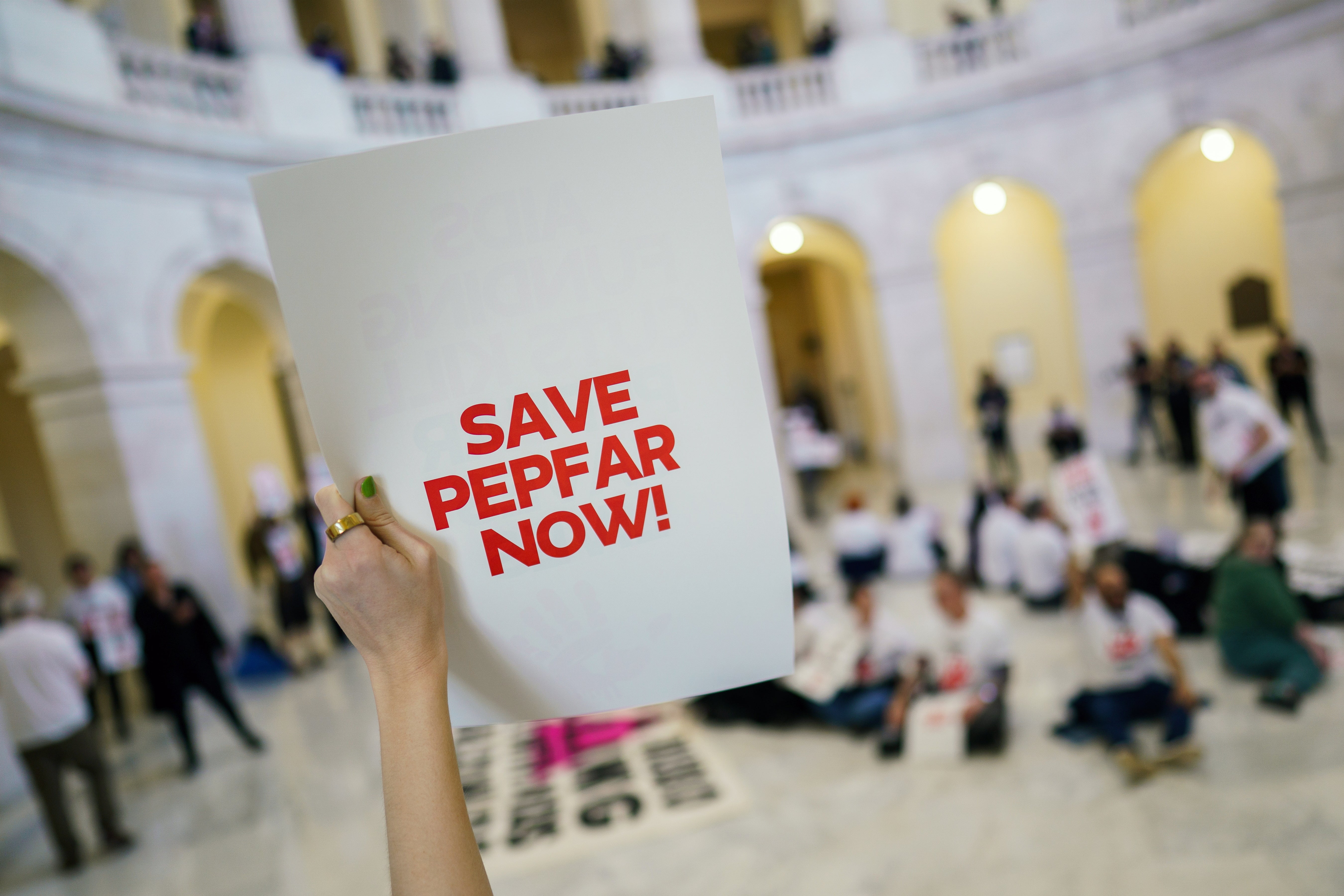 Protesters in the U.S. Capitol campaign against cuts to USAID's AIDS’ treatment program. A group estimated that nearly 15,000 have died since President Donald Trump froze the agency’s funding