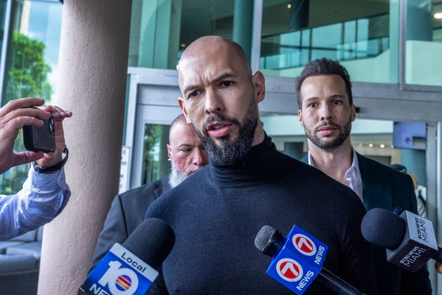 <p>Andrew Tate and his brother Tristan, behind, speaking to reporters after landing in Florida </p>