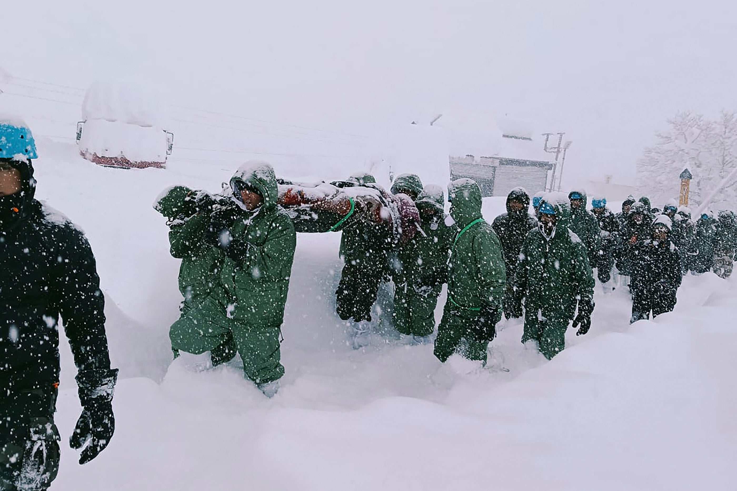 Rescuers carry road construction workers to safety following an avalanche in India's Himalayan state of Uttarakhand