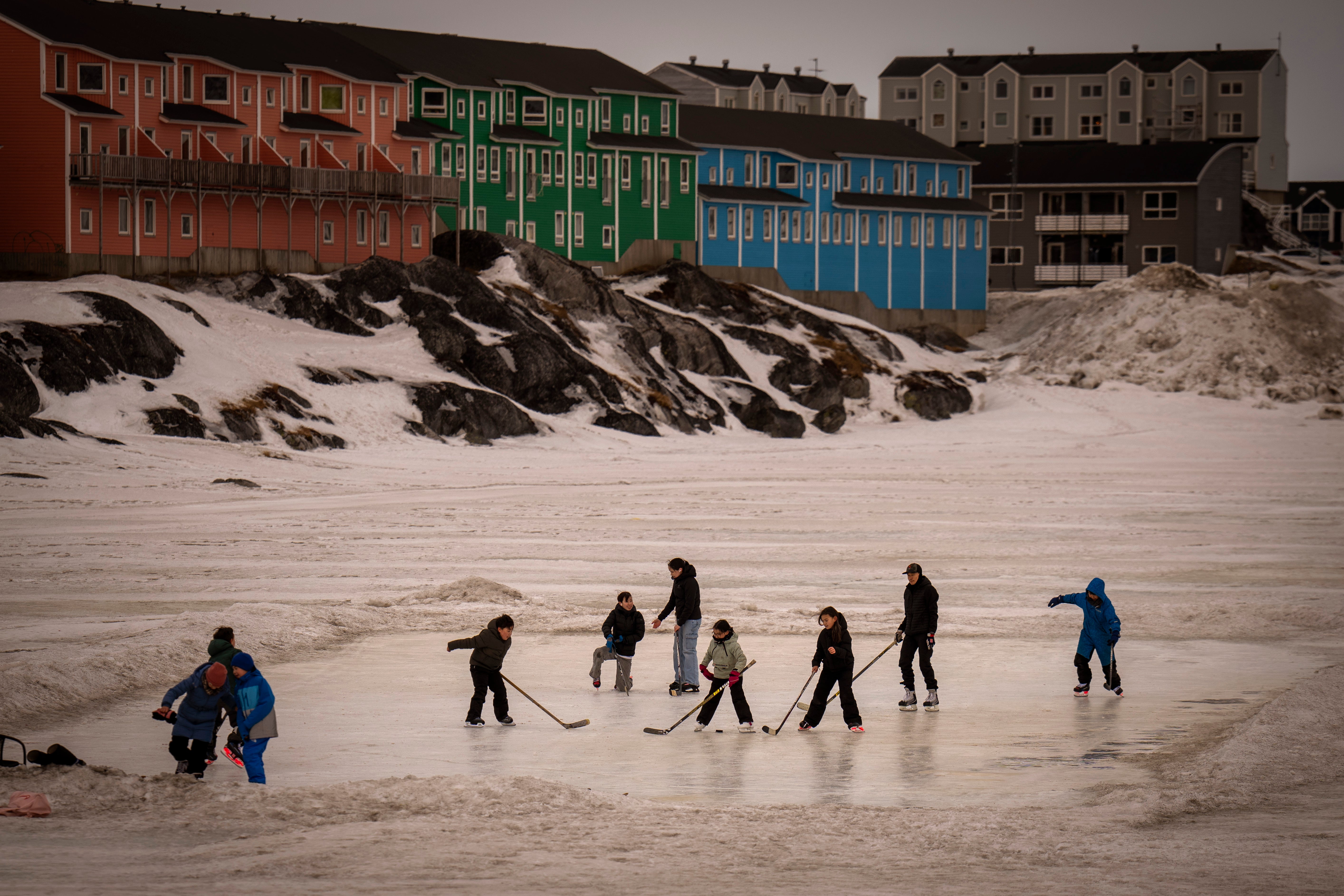 Children play on an icy surface in Nuuk, Greenland, Feb. 16, 2025. (AP Photo/Emilio Morenatti)