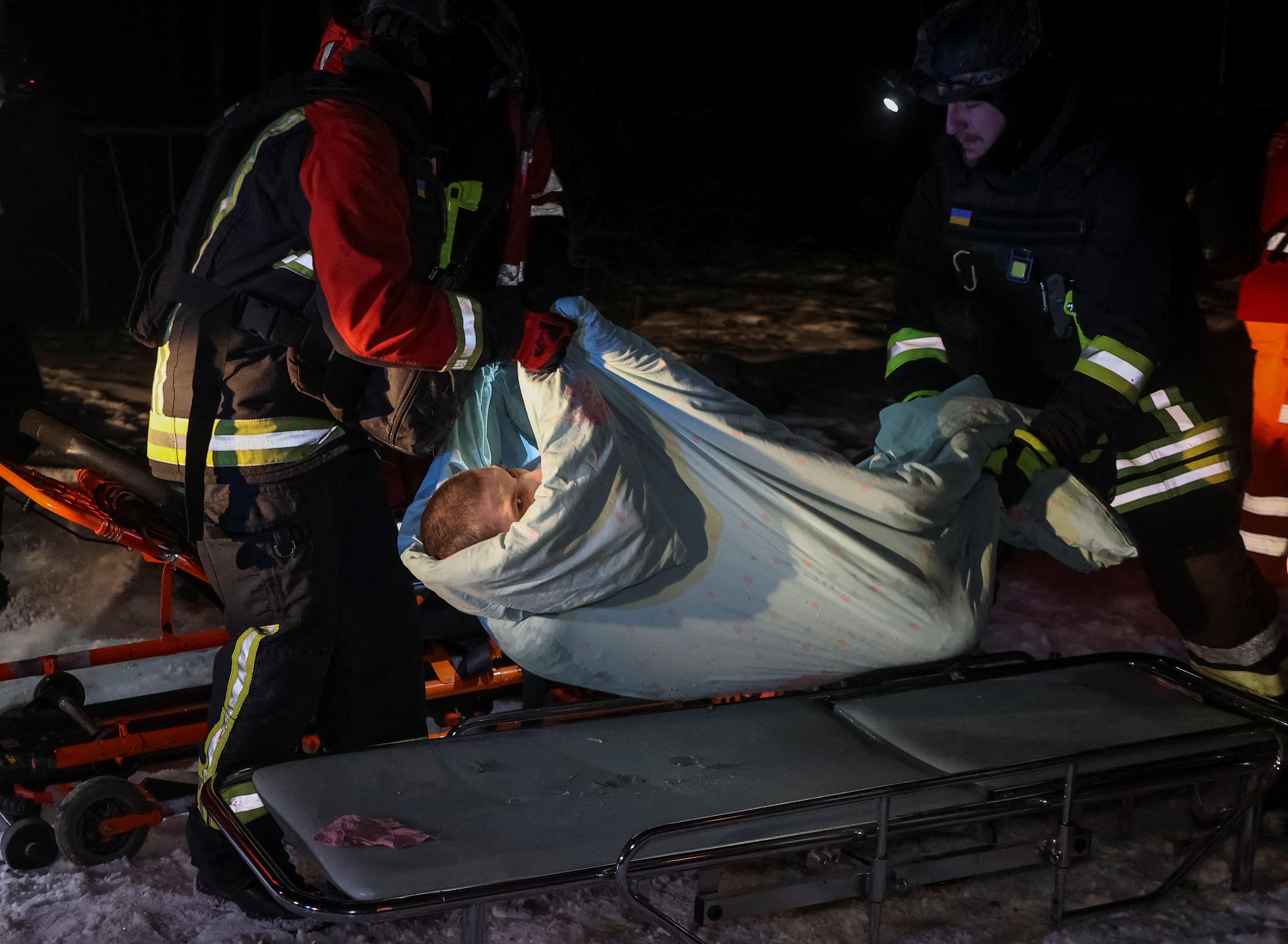 Resgatadores e trabalhadores médicos evacuam uma pessoa de um hospital atingido por uma greve de drones russos, em meio ao ataque da Rússia à Ucrânia, em Kharkiv