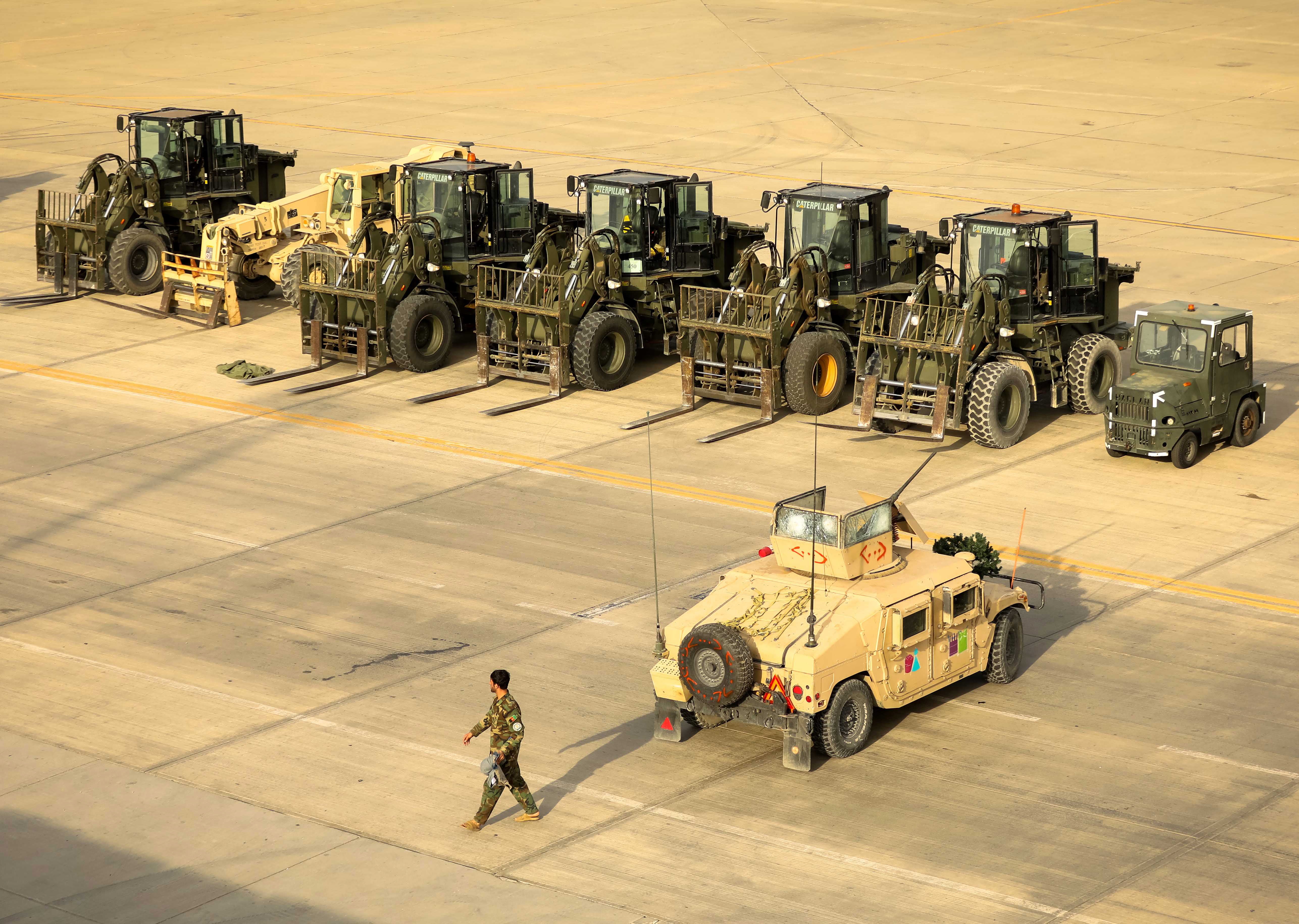 <p>File. An Afghan soldier passes an American military vehicle at the Bagram Air Base</p>