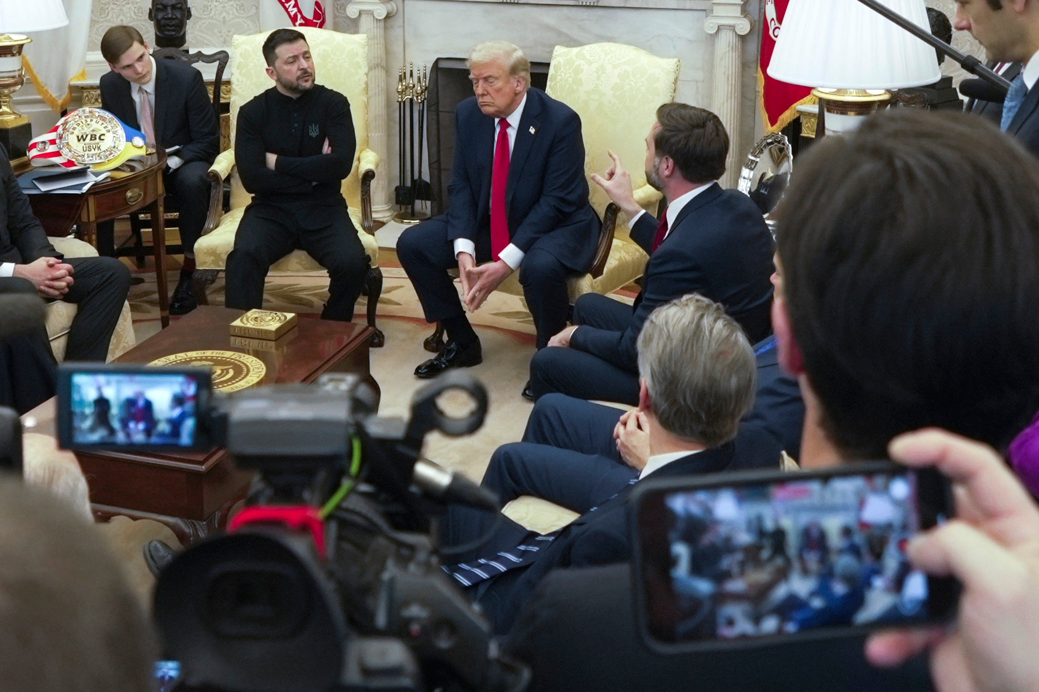 Vice President JD Vance, right, speaks with Ukrainian President Volodymyr Zelensky, left, as President Donald Trump, centre, listens in the Oval Office at the White House