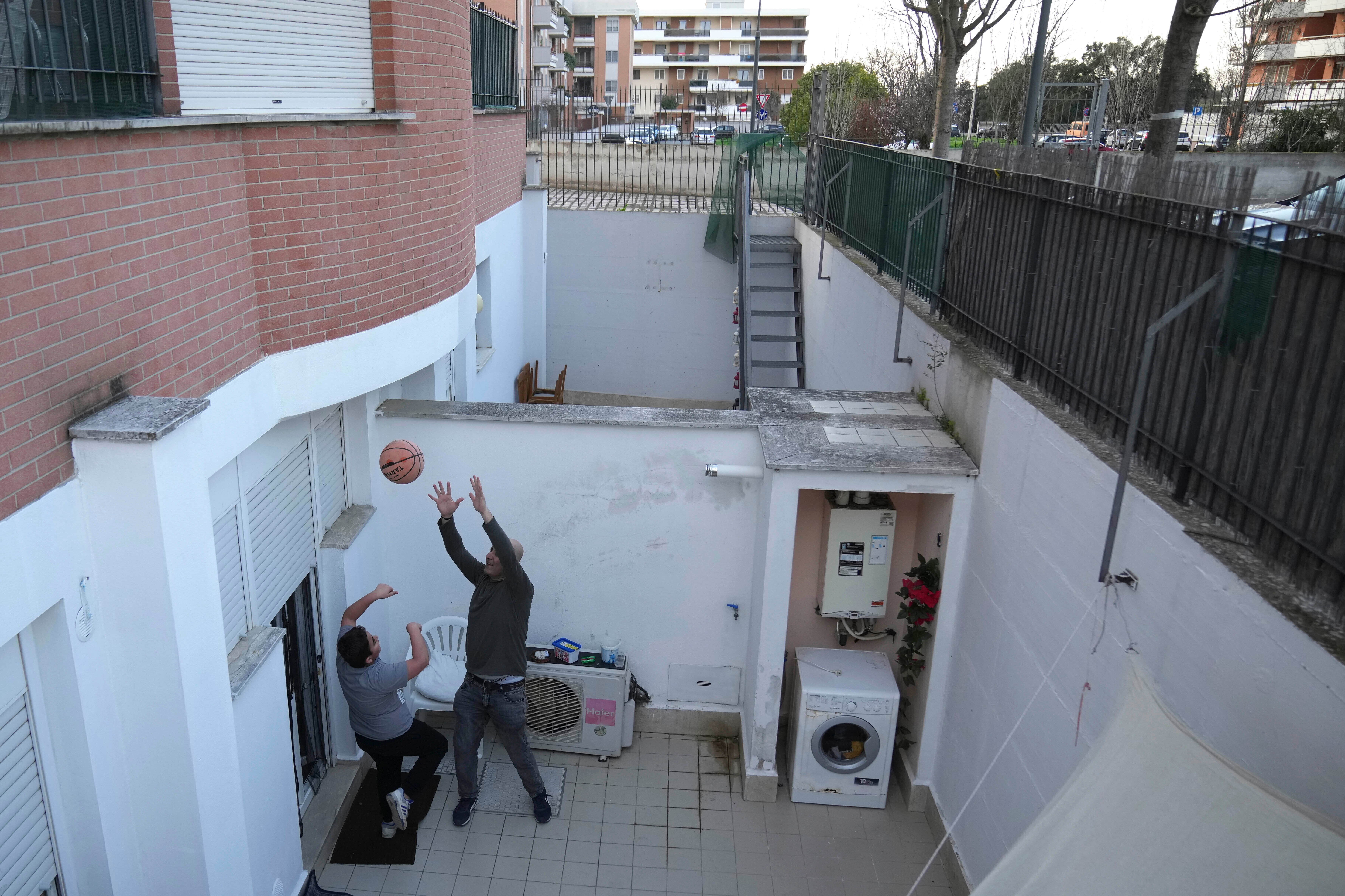 Hasan and Riad Zaheda play basketball in the courtyard of their home