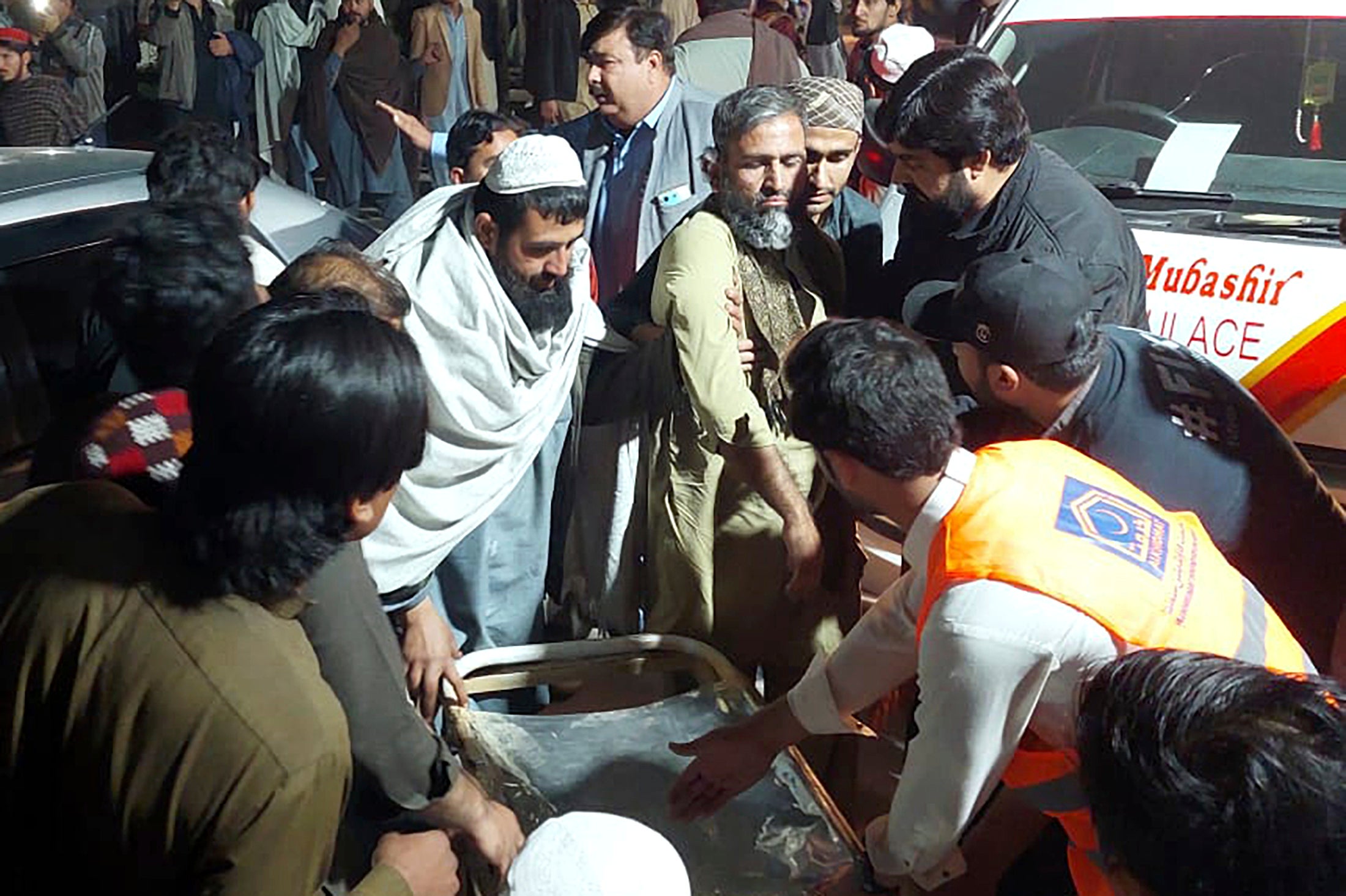 Rescue workers and volunteers help those injured by the blasts