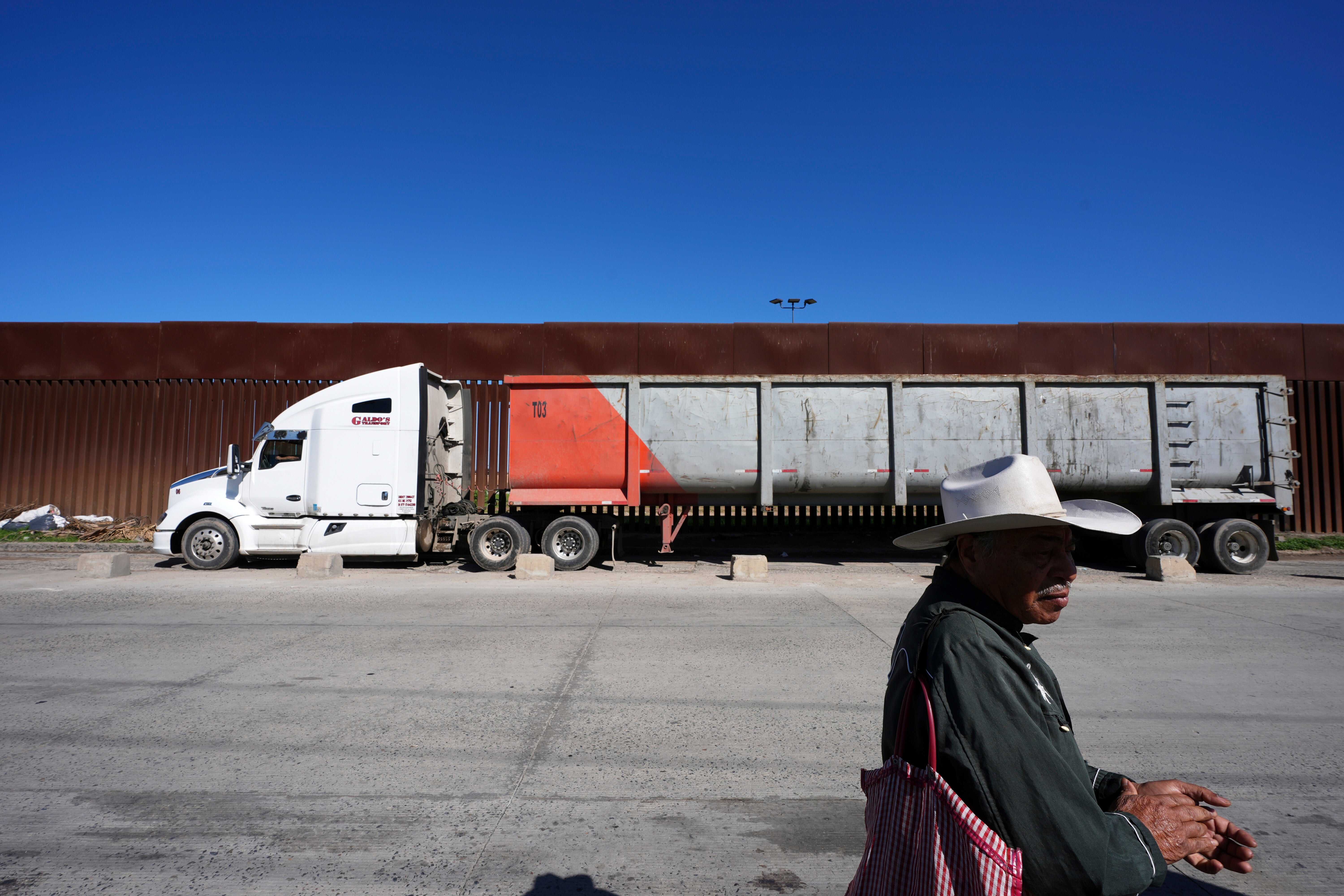 Susano Cordoba sells peanuts to truck drivers lining up to cross the border into the United States from Mexico