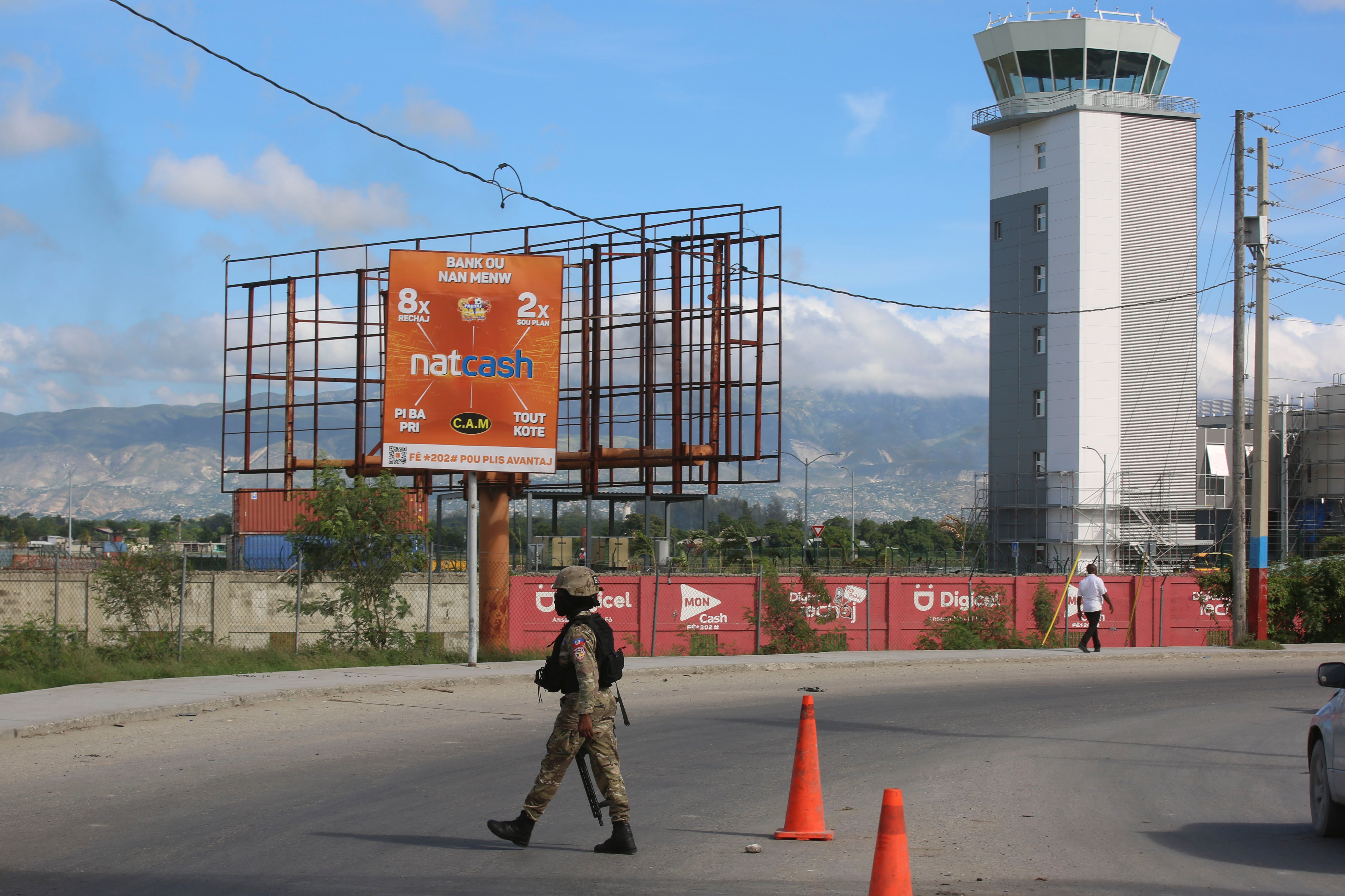 A police officer patrols the entrance of the Toussaint Louverture International Airport