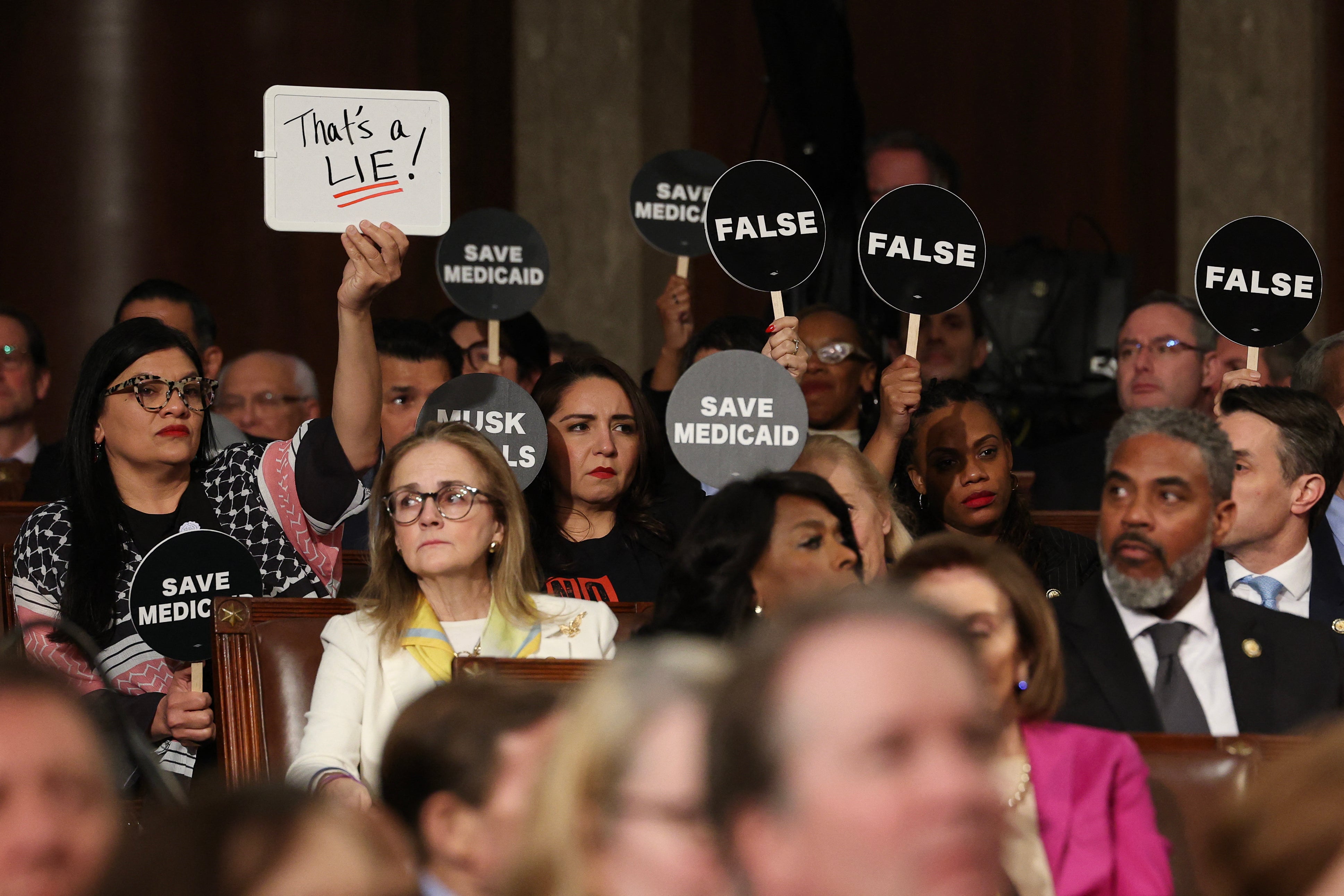 Democrats hold protest signs US President Donald Trump speaks during an address to a joint session of Congress at the US Capitol in Washington, DC, on March 4, 2025