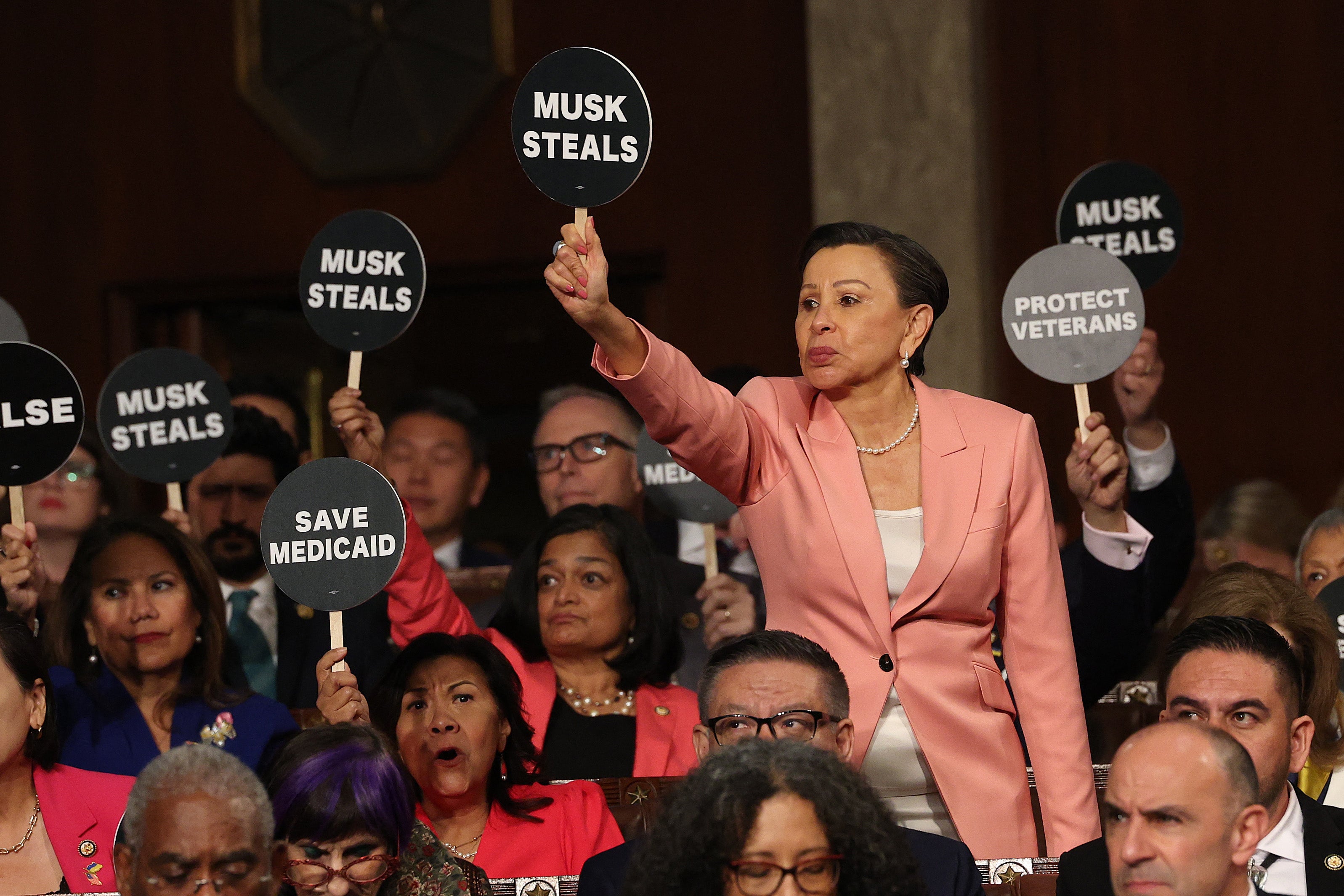 US Representative Nydia Velazquez (D-NY) holds a "Musk Steals" protest sign with fellow Democrats