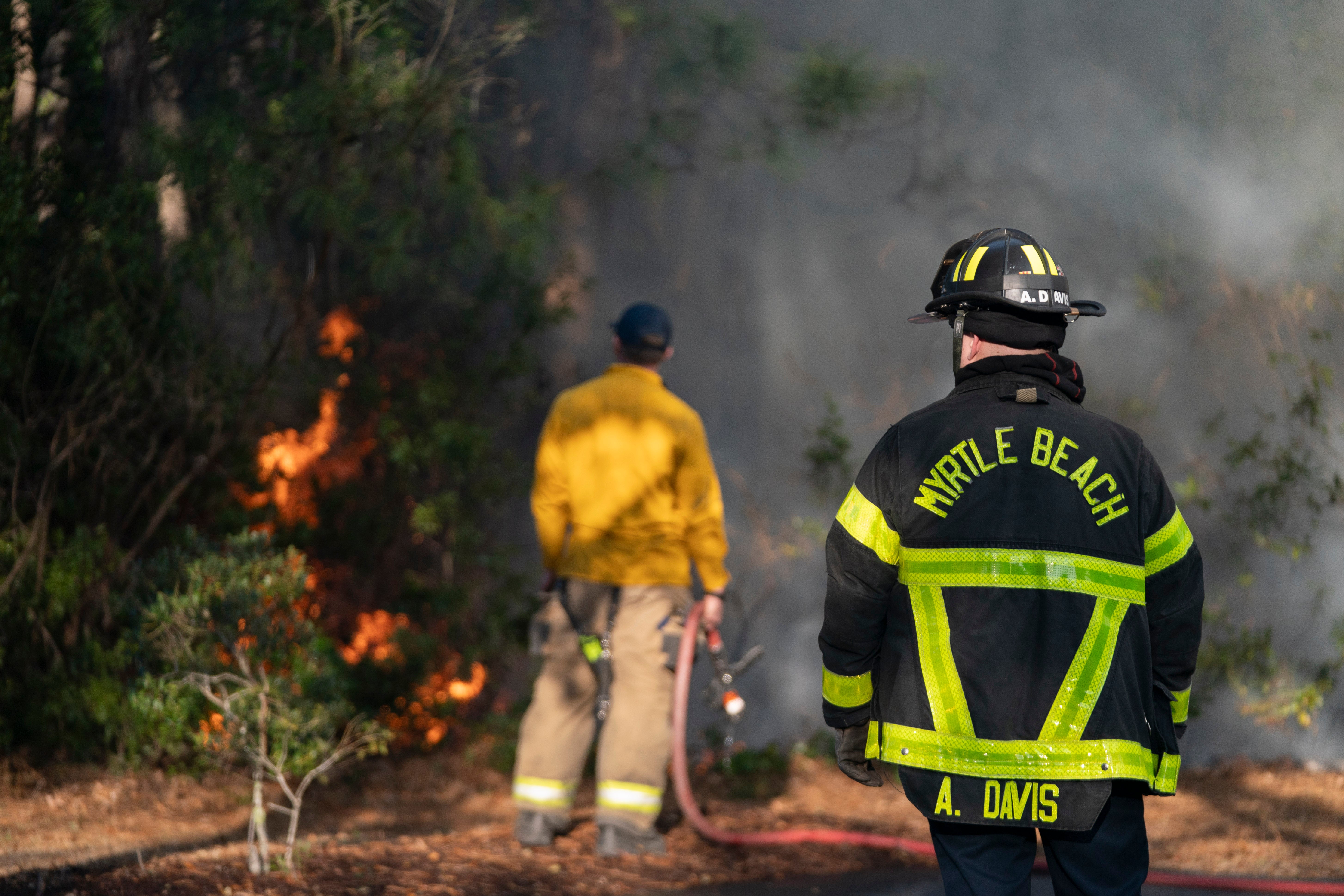 Firefighters attend to a flare-up in the Carolina Forest neighborhood on 2 March 2025 in Myrtle Beach, South Carolina