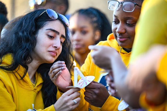 <p>Jaylen Lewis, right, helps light Virginia Olide's candle during a vigil for Caleb Wilson at Southern University</p>