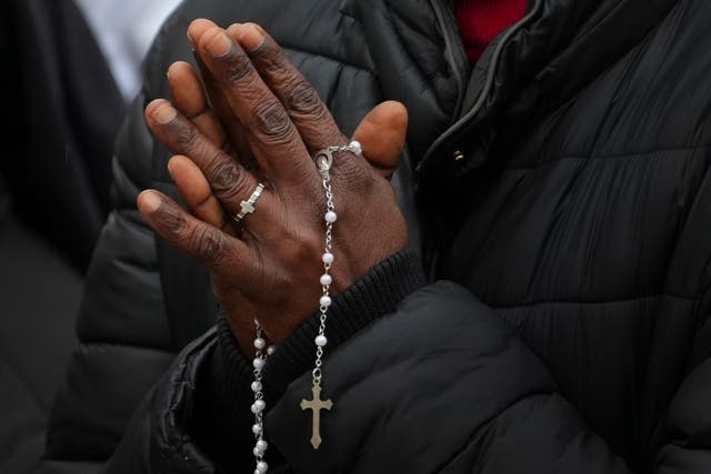 <p>A nun holds rosary beads in front of the Gemelli hospital where Pope Francis is receiving care</p>