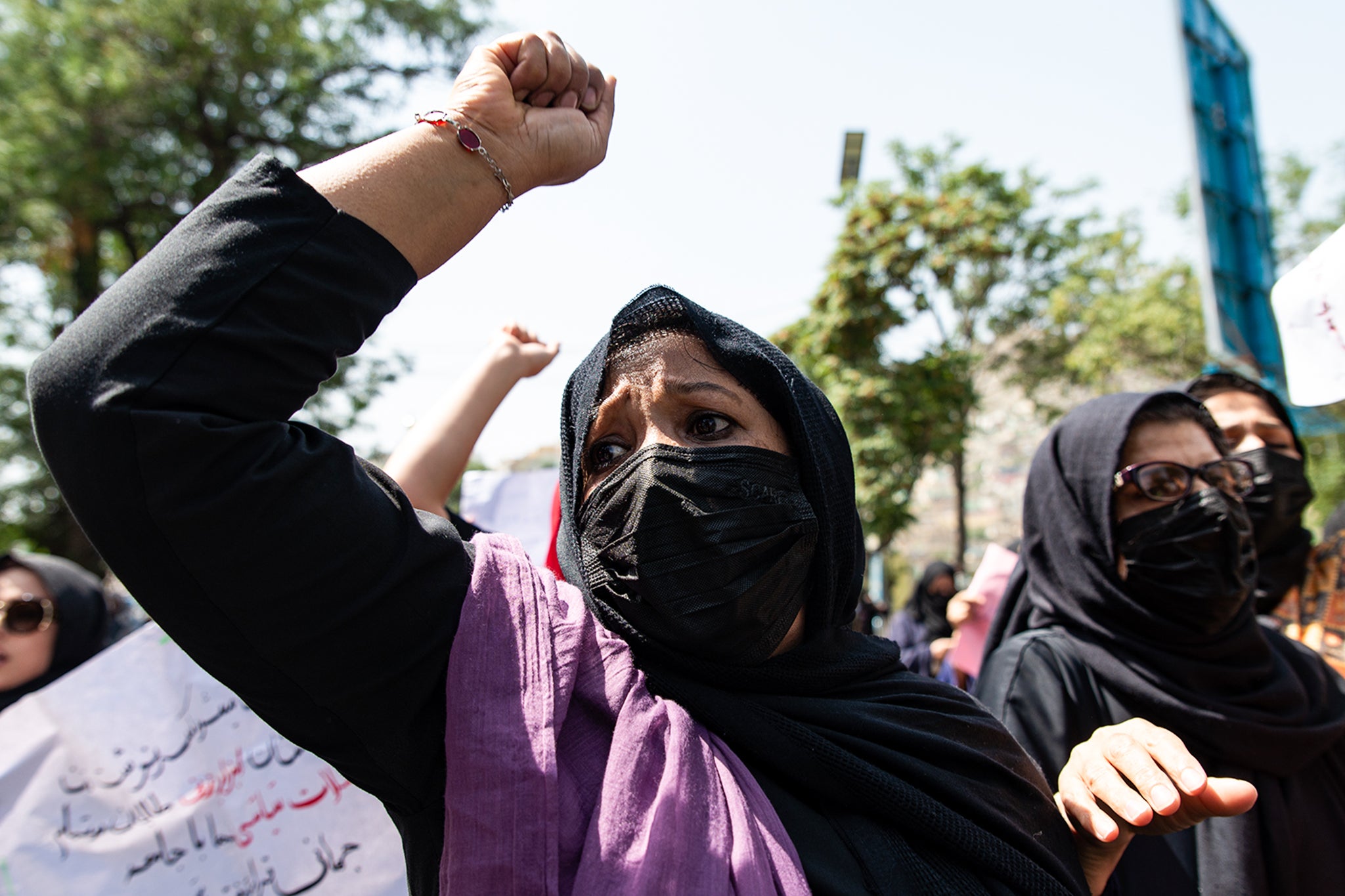 Taliban fighters fire into the air as they disperse a rare rally by women as they chanted 