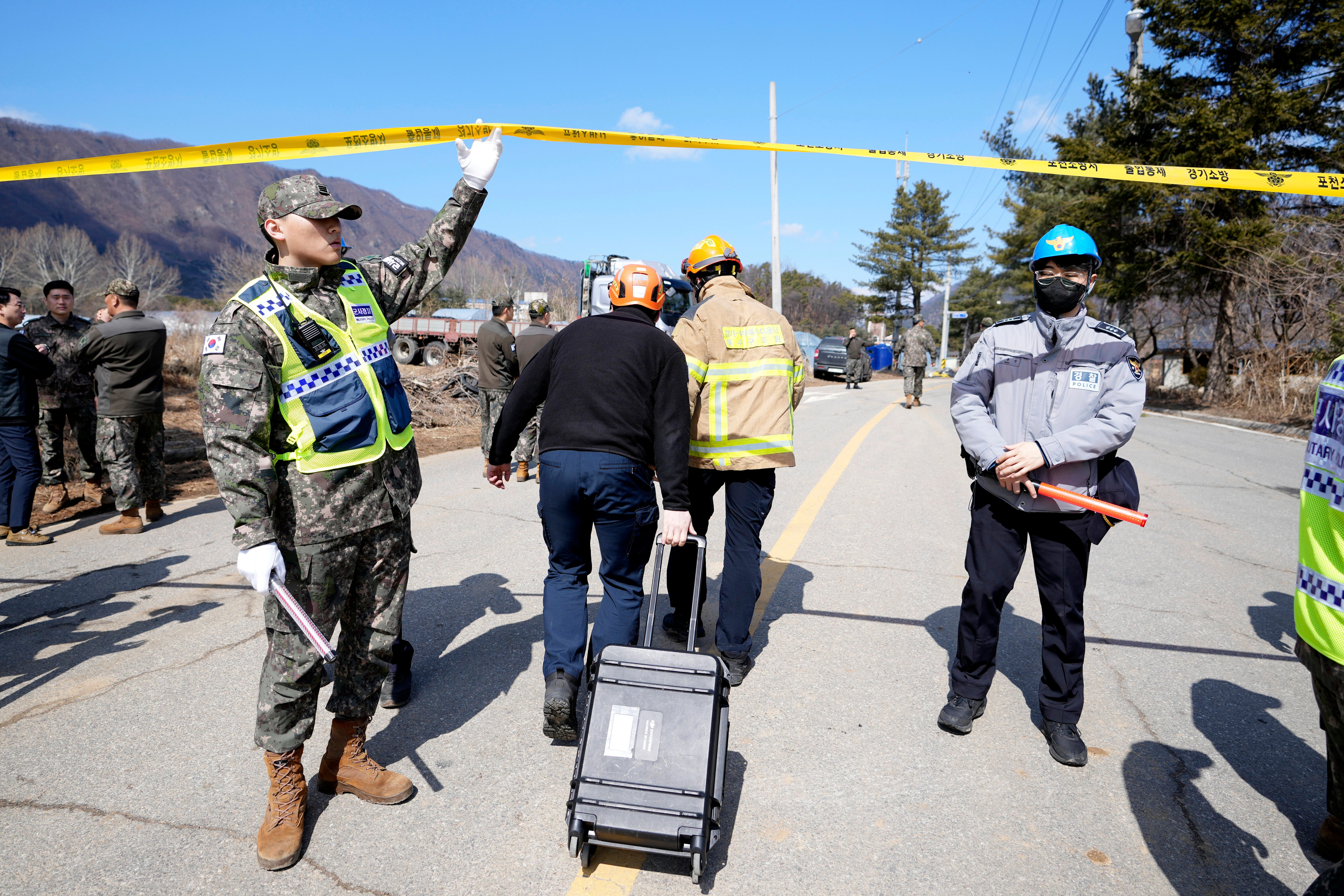 Firefighters arrive near the scene where a South Korean fighter jet accidentally dropped bombs on a civilian area