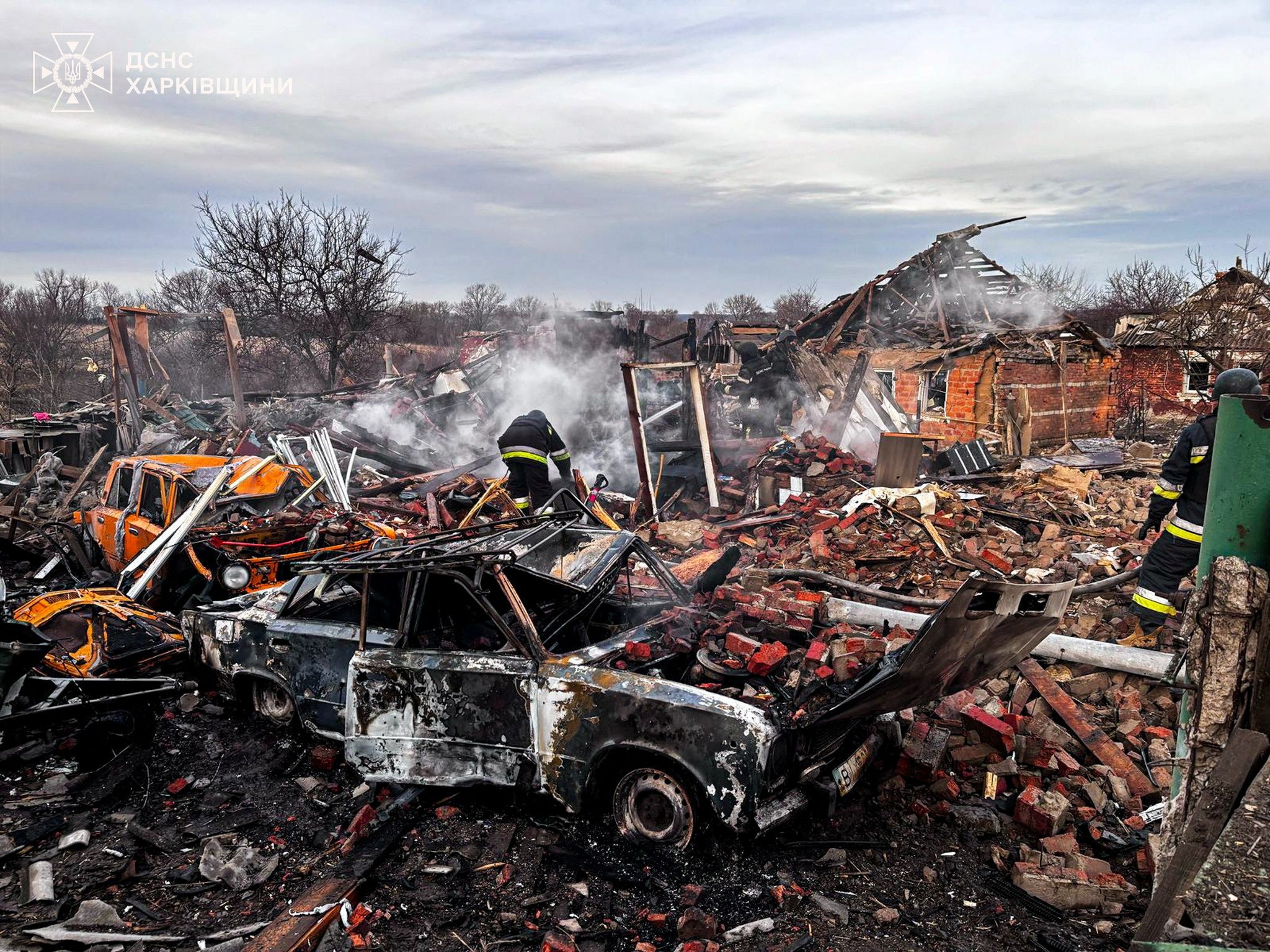 Firefighters work at the site of houses destroyed by a Russian air strike, amid Russia's attack on Ukraine, in the village of Slatyne