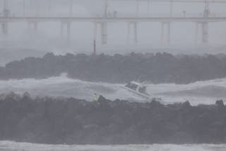 A police boat looks for a jet ski rider who went missing amid record-breaking waves as the outer fringe of Tropical Cyclone Alfred started whipping eastern Australia, in Coolangatta on 6 March 2025