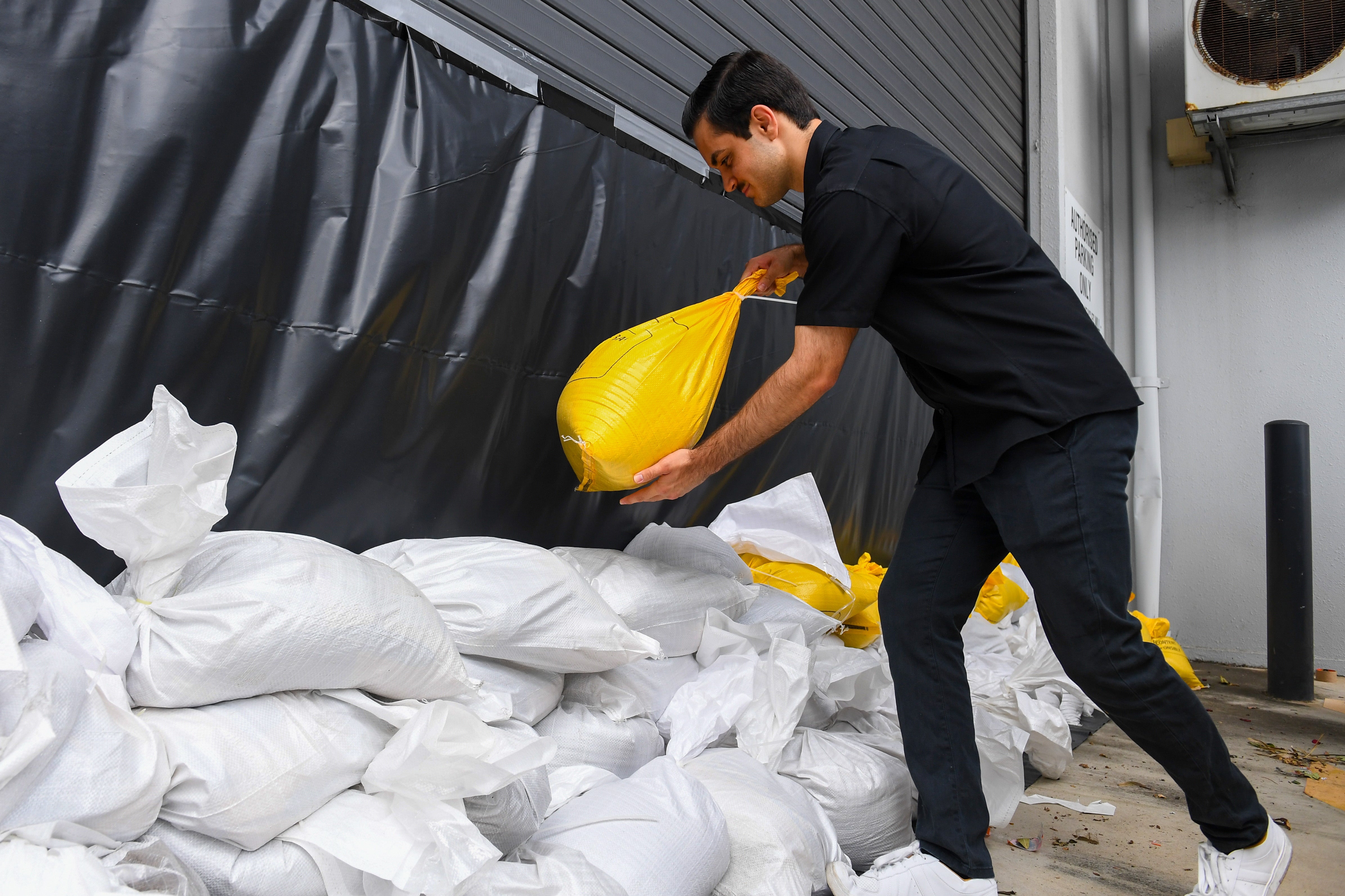 Noah, a worker at Booth engineers and Associates in Rocklea, stacks sandbags in Brisbane, Queensland, Australia, 06 March 2025