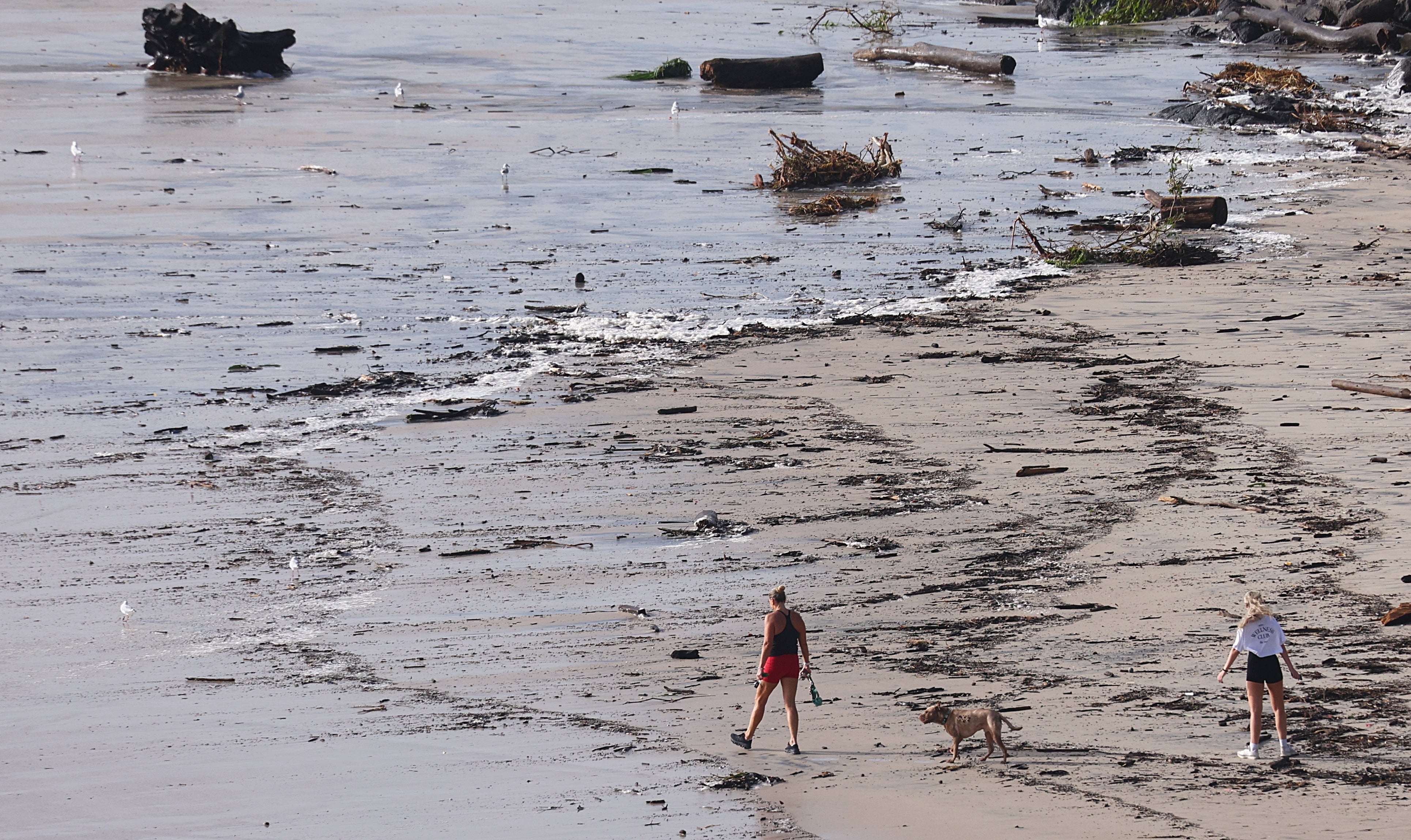 People walk along the beach amongst debris and beach erosion at Duranbah Beach in Northern New South Wales, Australia, 06 March 2025