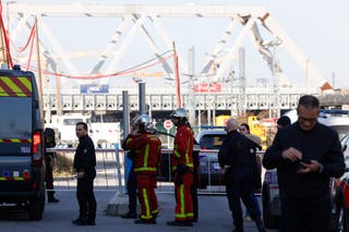 French police officers, next to firefighters, block the access to the SNCF's freight area in Saint-Denis