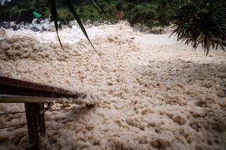 Sea foam is pushed by record-breaking waves caused by the outer fringe of Tropical Cyclone Alfred at Point Danger in Coolangatta