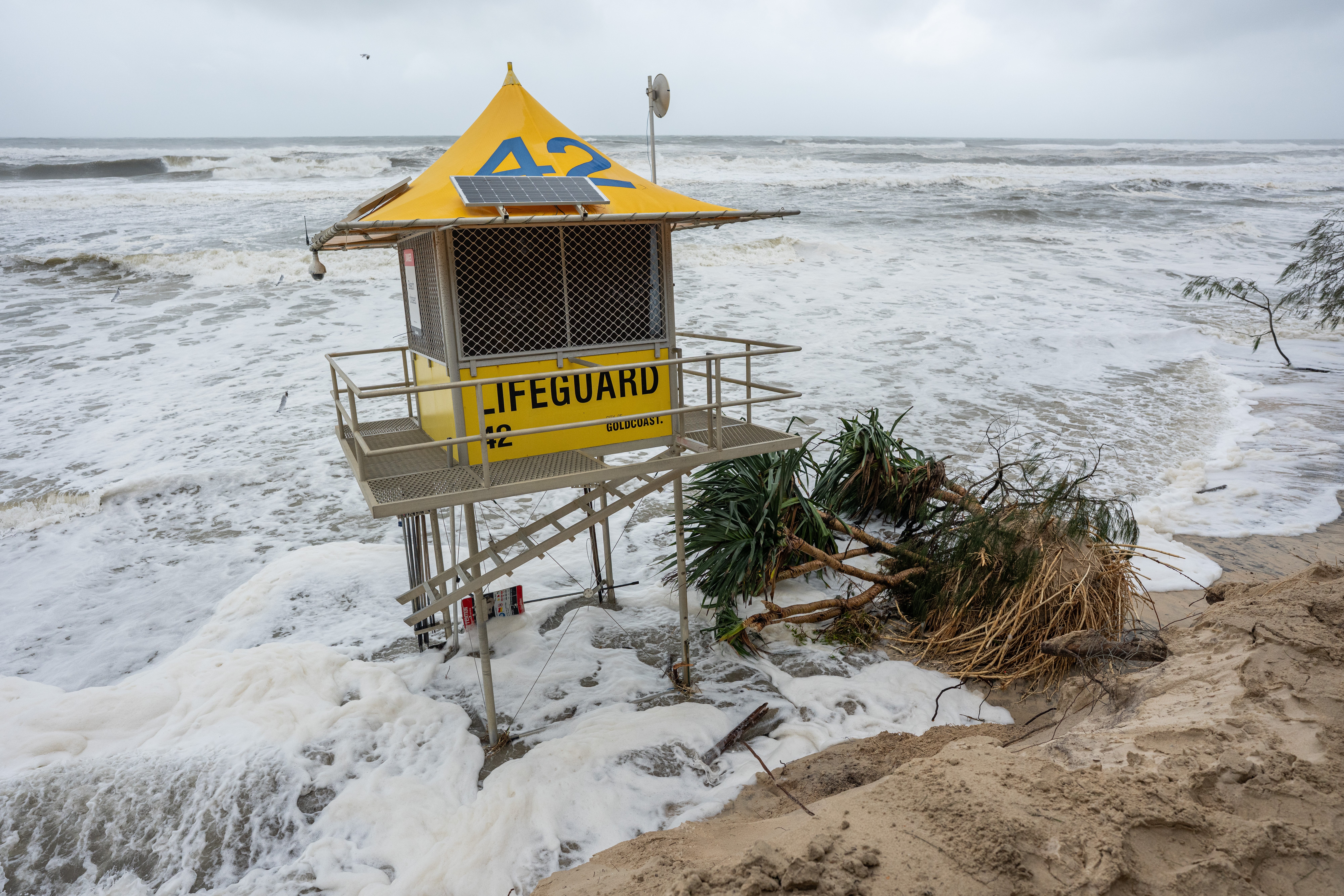 A lifeguard post and a collapsed tree on the eroded beach shore on 7 March 2025 at the Southport spit in the Gold Coast, Australia