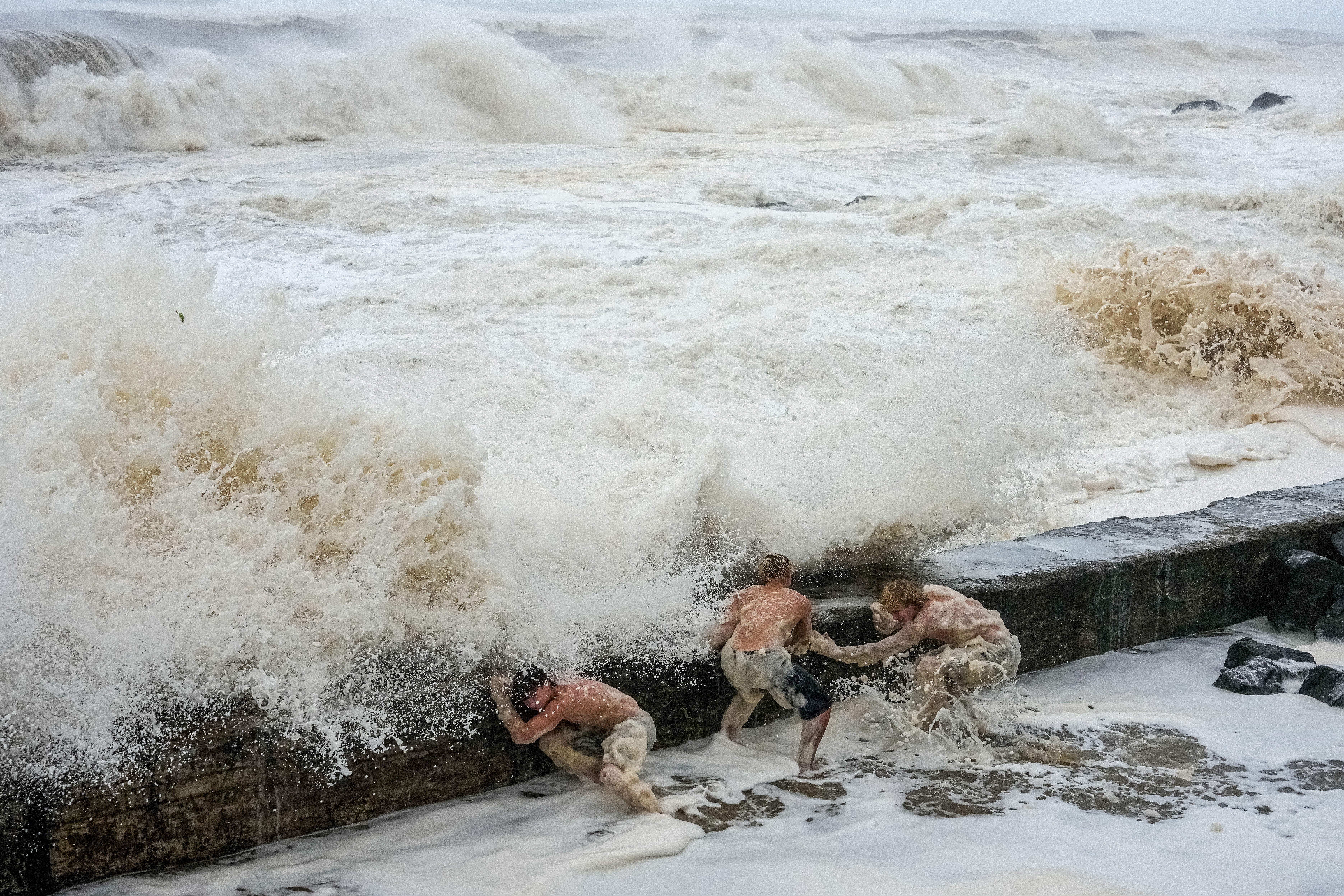 People evade a crashing wave in Tweed Heads