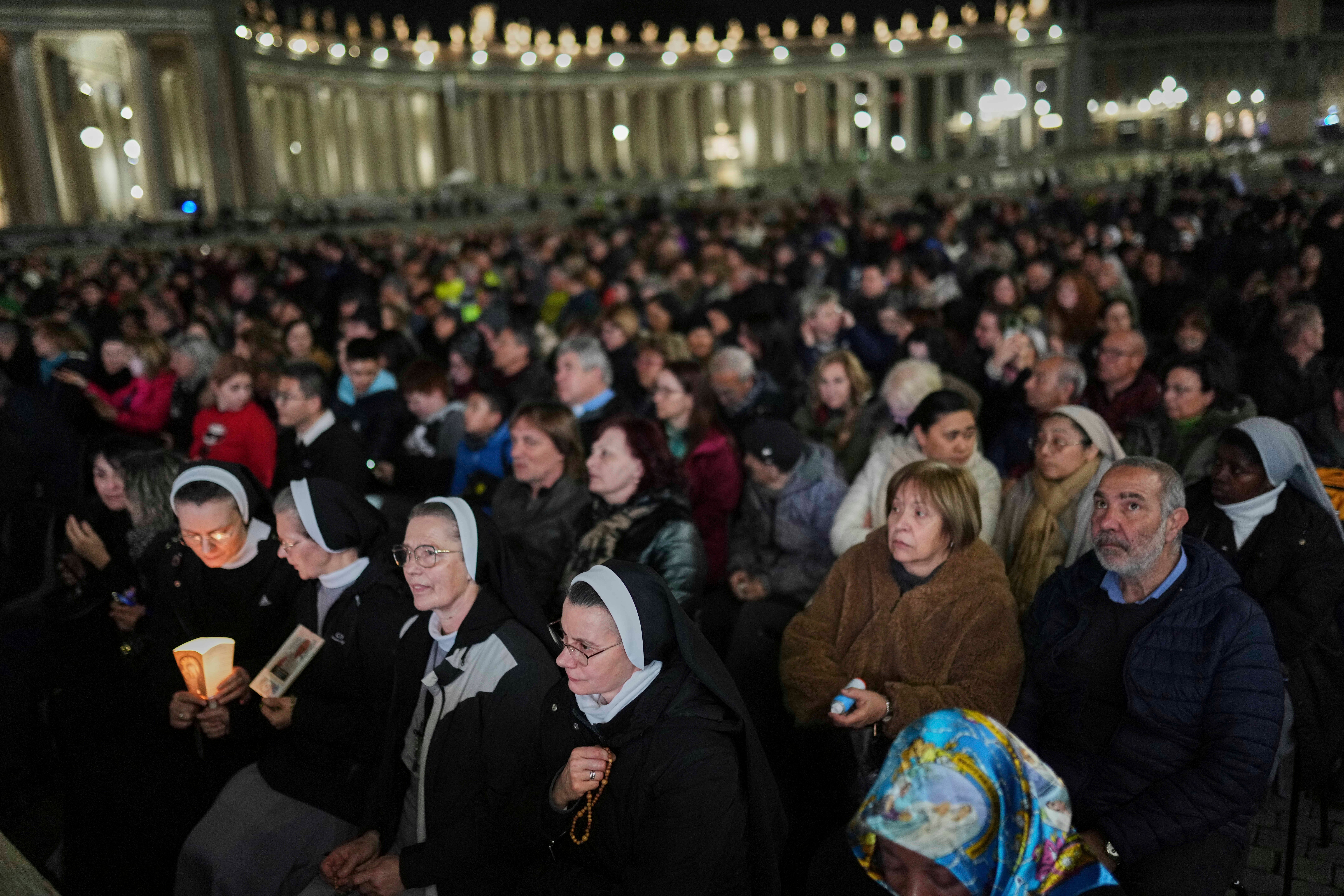 Os adoradores católicos se reúnem para uma oração do Rosário para o Papa Francisco na Praça de São Pedro