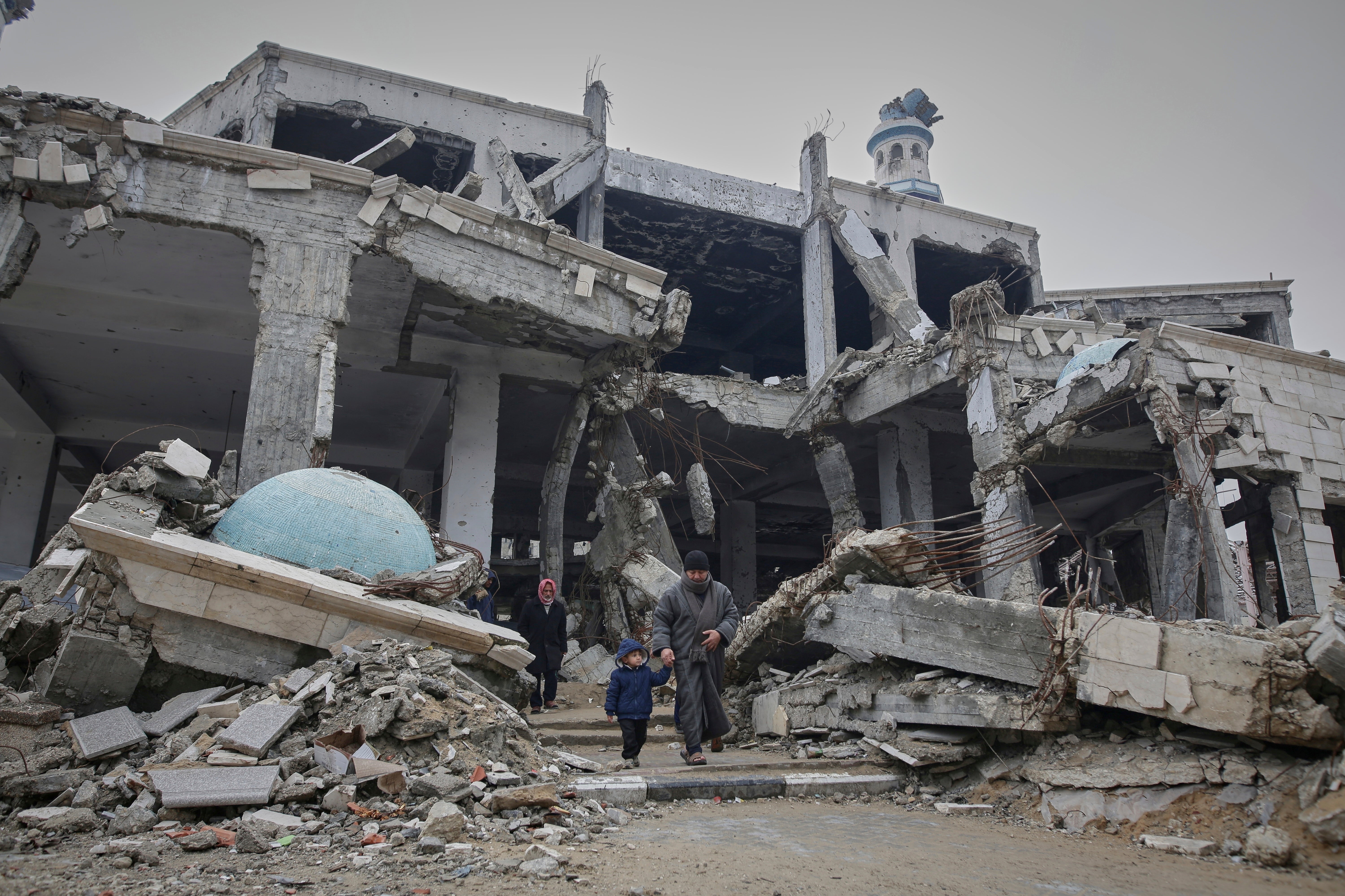 Palestinians leave after prayers at the Imam Shafi'i Mosque in Gaza city, which has been badly damaged by Israeli strikes