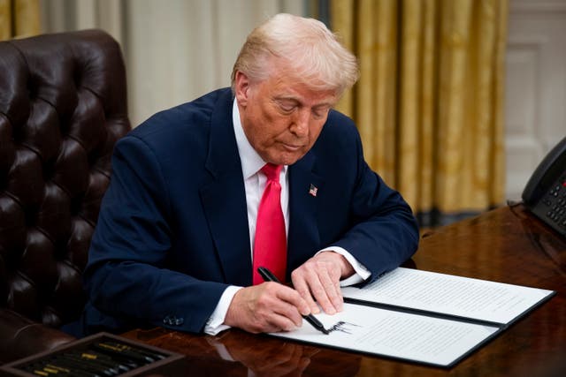 <p>Donald Trump signing an executive order in the Oval Office of the White House</p>