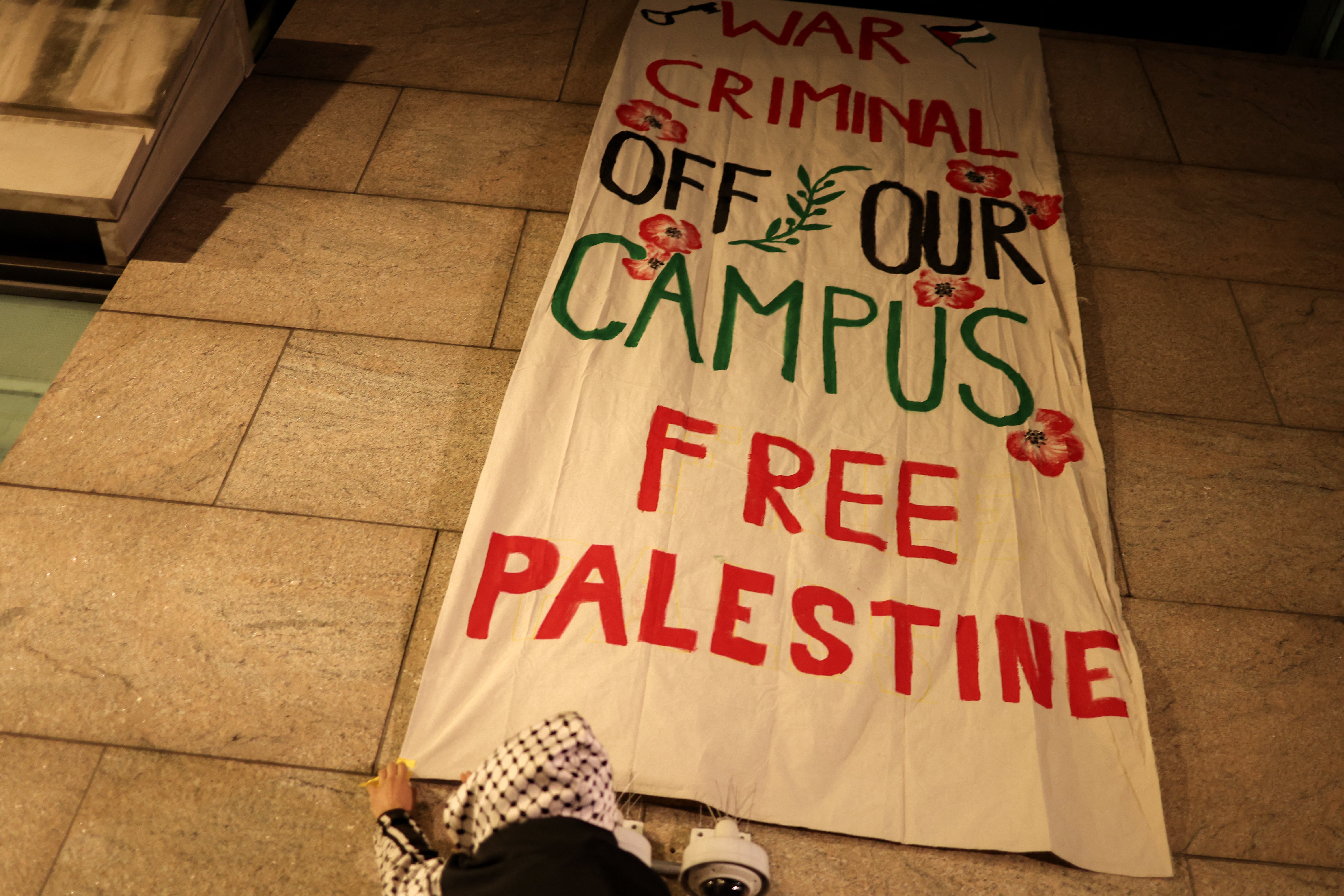 Pro-Palestinian protesters hang a banner as they gather outside the campus of Columbia University in New York City on March 4 (AFP via Getty Images)