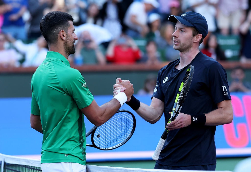 Djokovic shakes hands at the net after his three set defeat against Botic van de Zandschulp