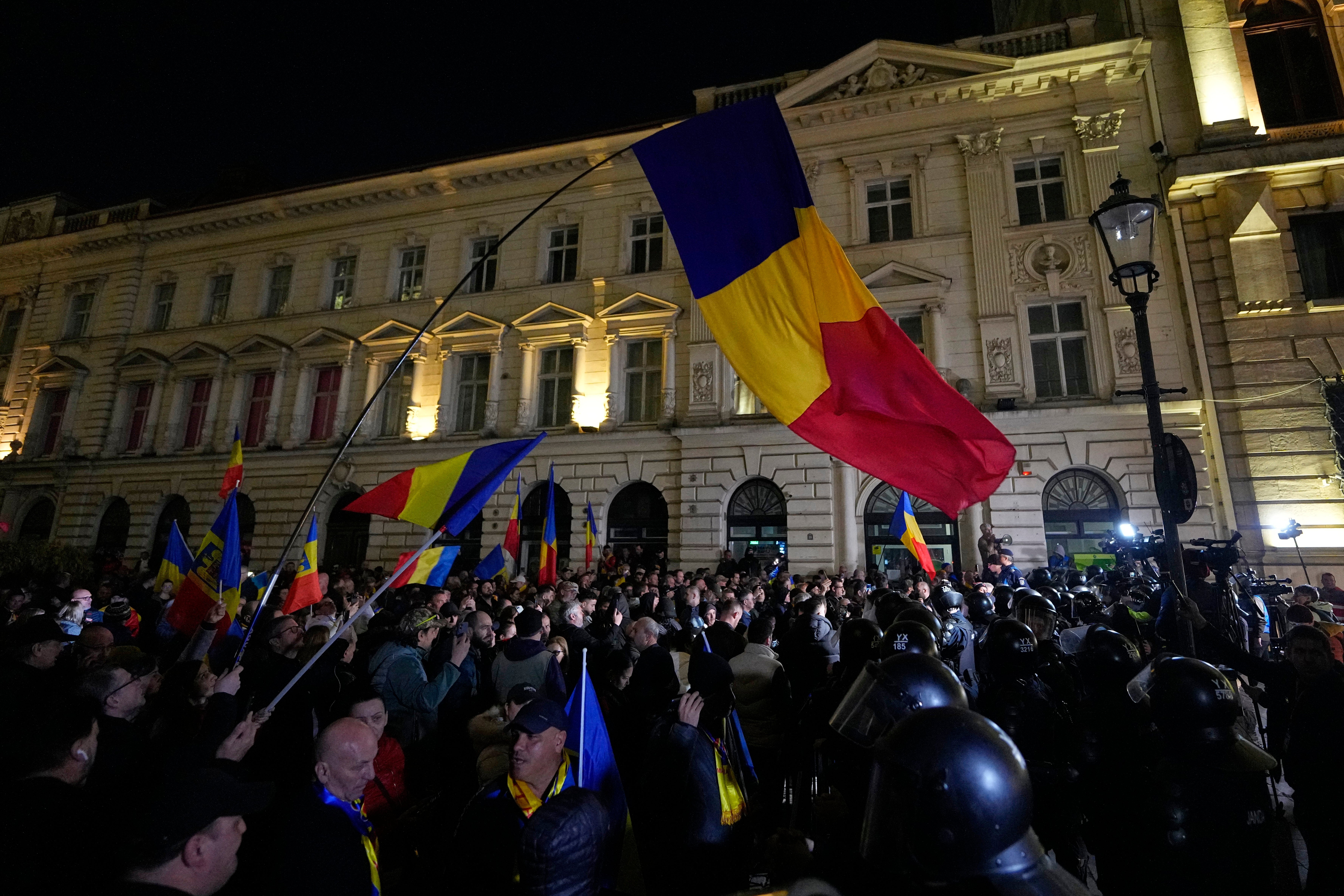 Supporters of Calin Georgescu protest after the decision to bar him from re-running