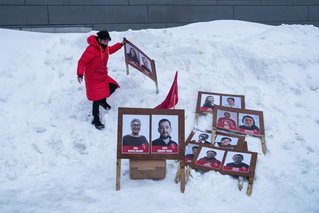 <p>A woman carries political placards in Nuuk, Greenland ahead of the March 11 election</p>