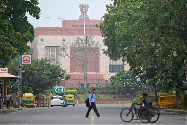 <p>File. People walk past the new parliament building in New Delhi, India, on 26 June 2023</p>