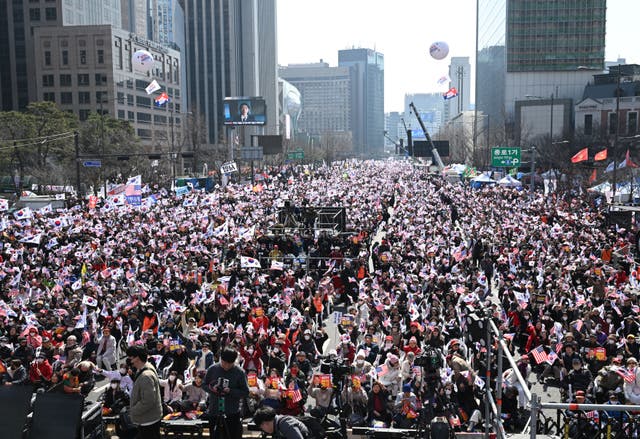 <p>Supporters of South Korean president Yoon Suk Yeol wave South Korean and the US flags during a rally in downtown Seoul</p>