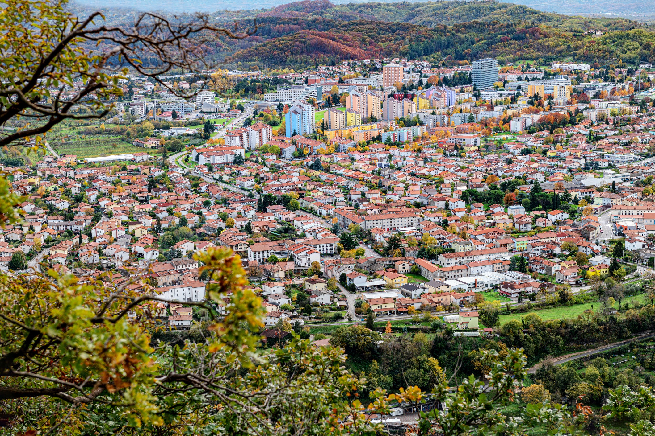 Multicoloured tower blocks and terracotta-roofed buildings form much of Nova Gorica surrounded by lush greenery