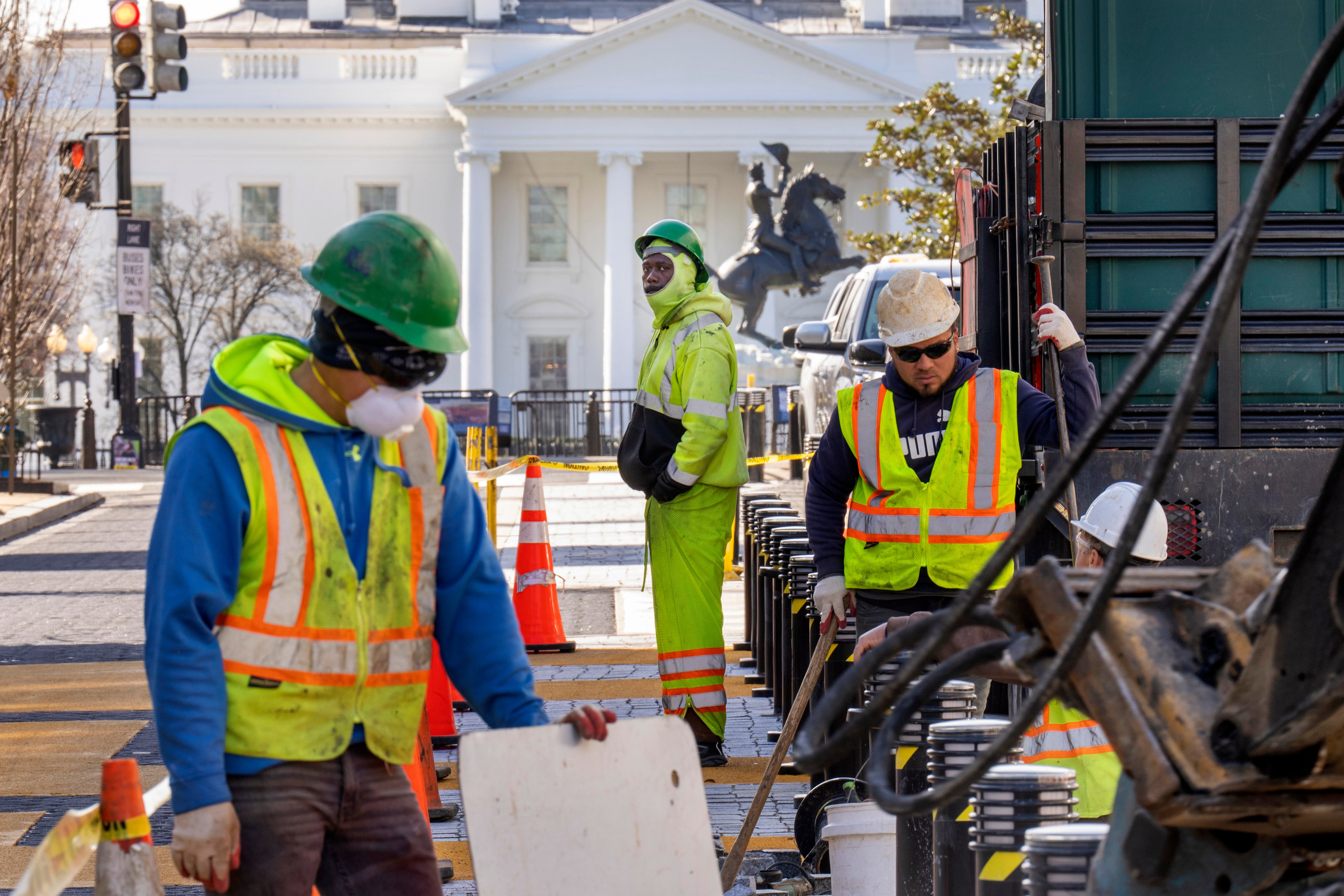<p>With the White House in the background, a worker watches as demolition begins on the Black Lives Matter mural</p>