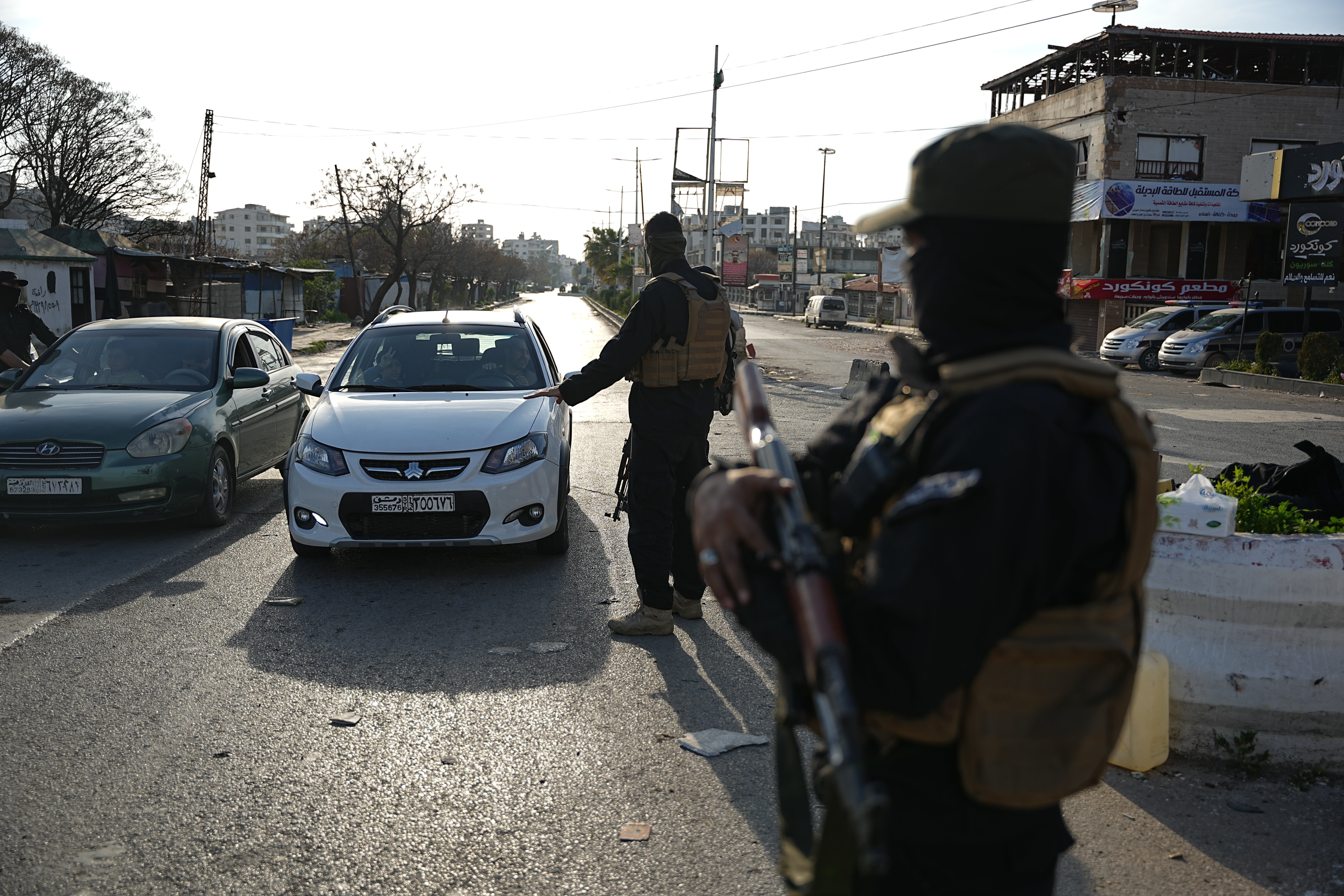 Syrian security forces stop vehicles at a checkpoint