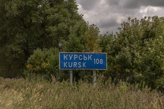 A road sign showing the distance to the Russian town of Kursk next to the destroyed border crossing point with Russia, in the Sumy region