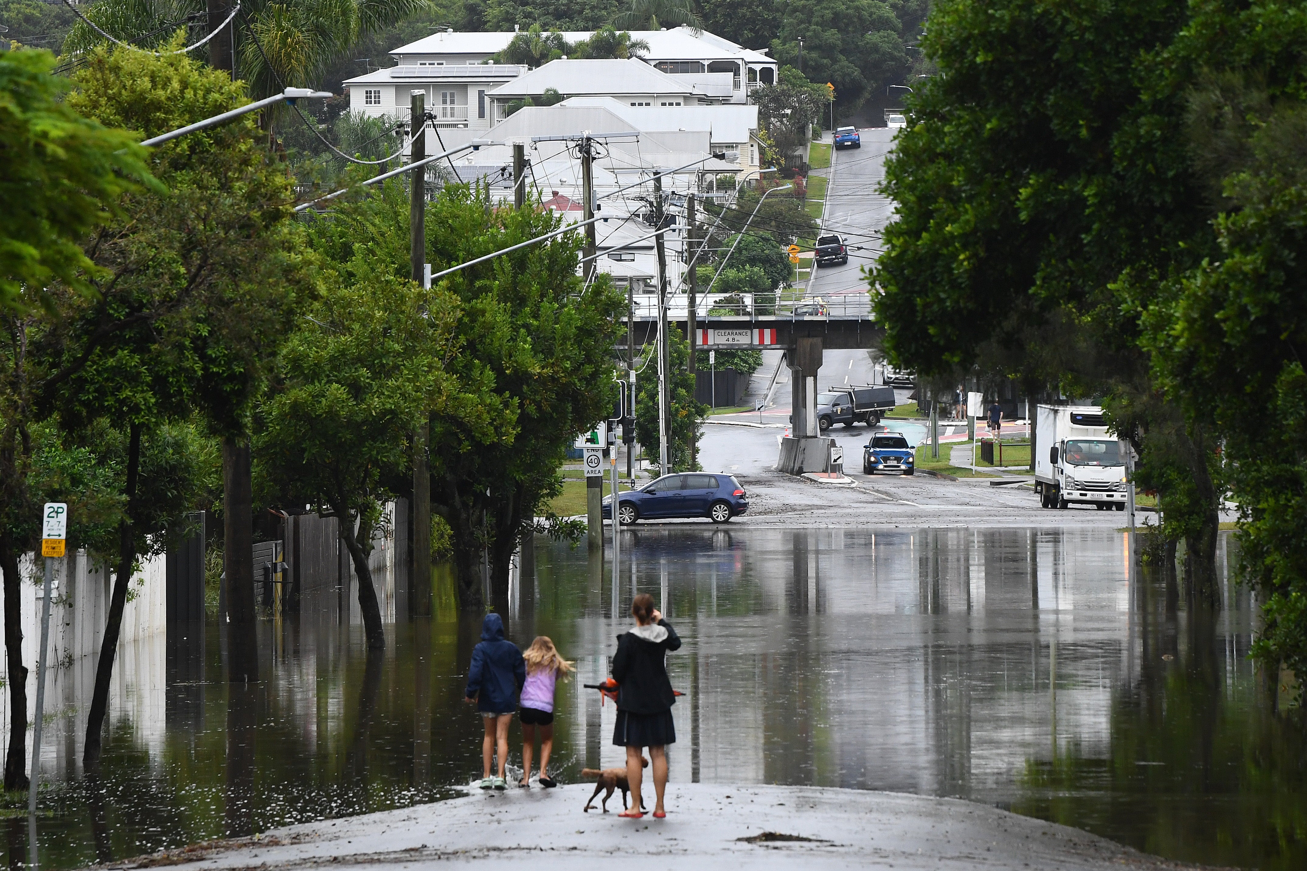 Residents look at flooding on their street in Newmarket, Brisbane, on 10 March 2025