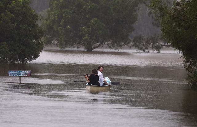 <p>People paddle a canoe down a street in South Lismore, New South Wales, on 10 March 2025</p>