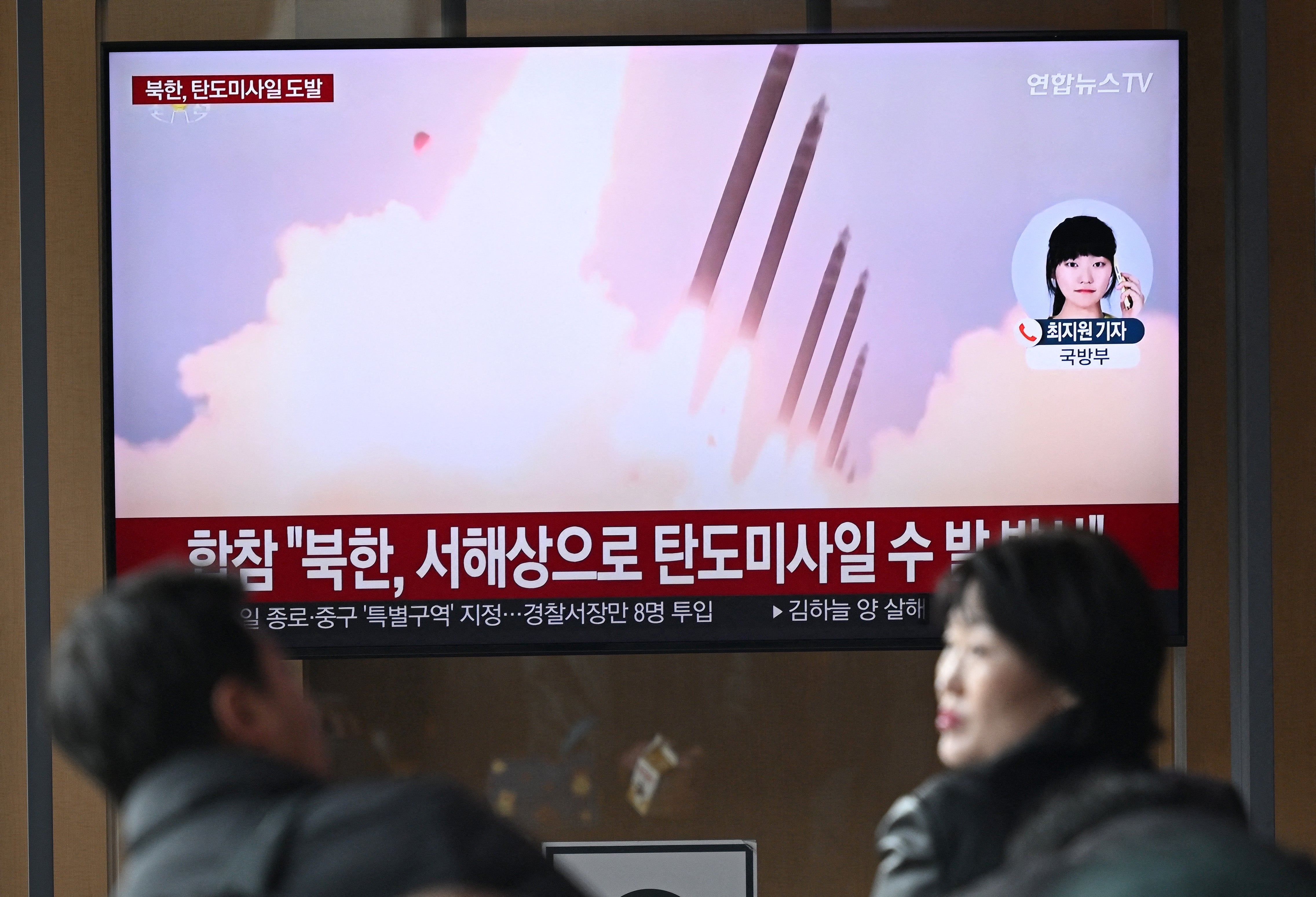 File: People watch a television screen showing a news broadcast with file footage of a North Korean missile test, at a train station in Seoul on March 10, 2025