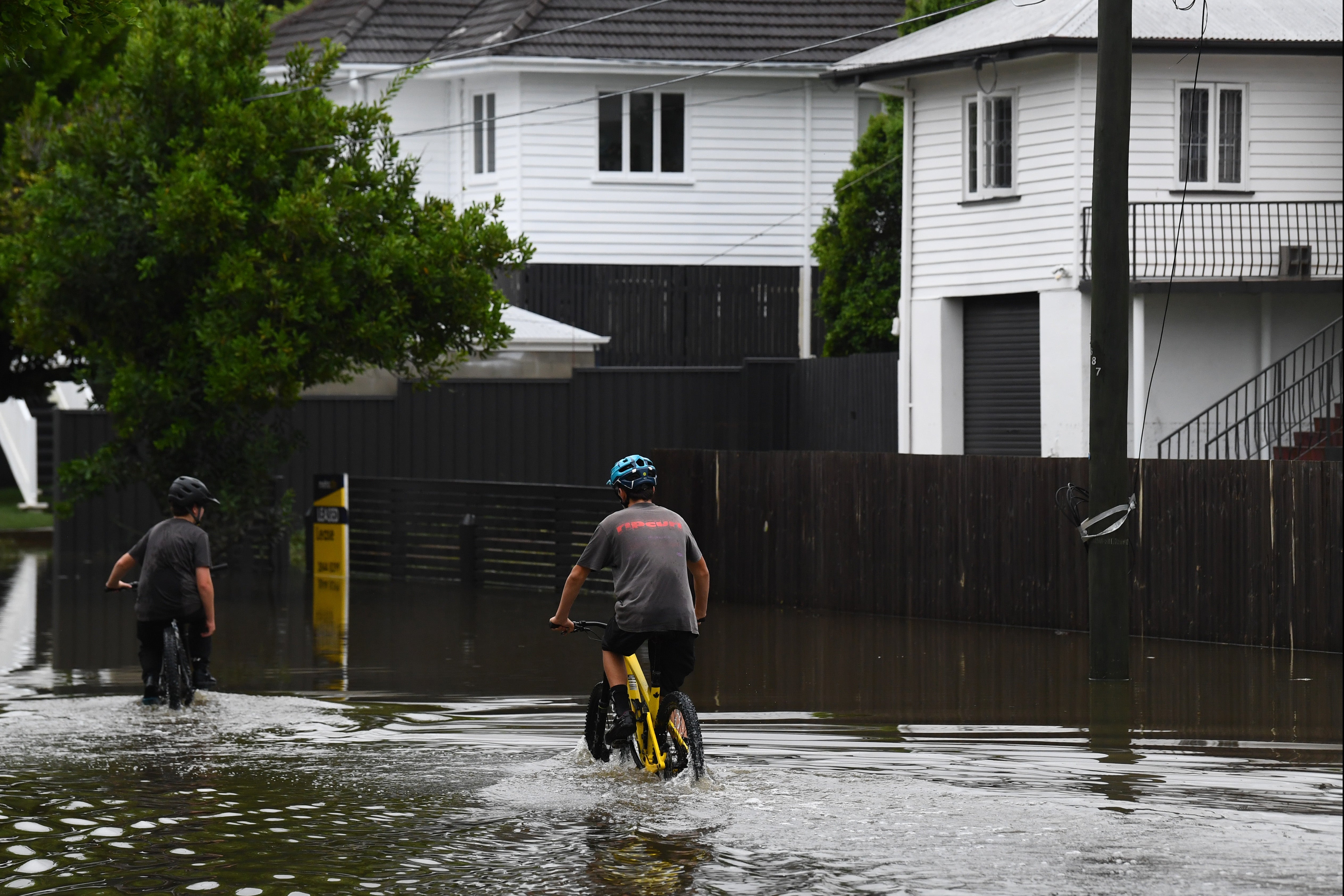 A cyclist rides through flooding in Newmarket, Brisbane, on 10 March 2025