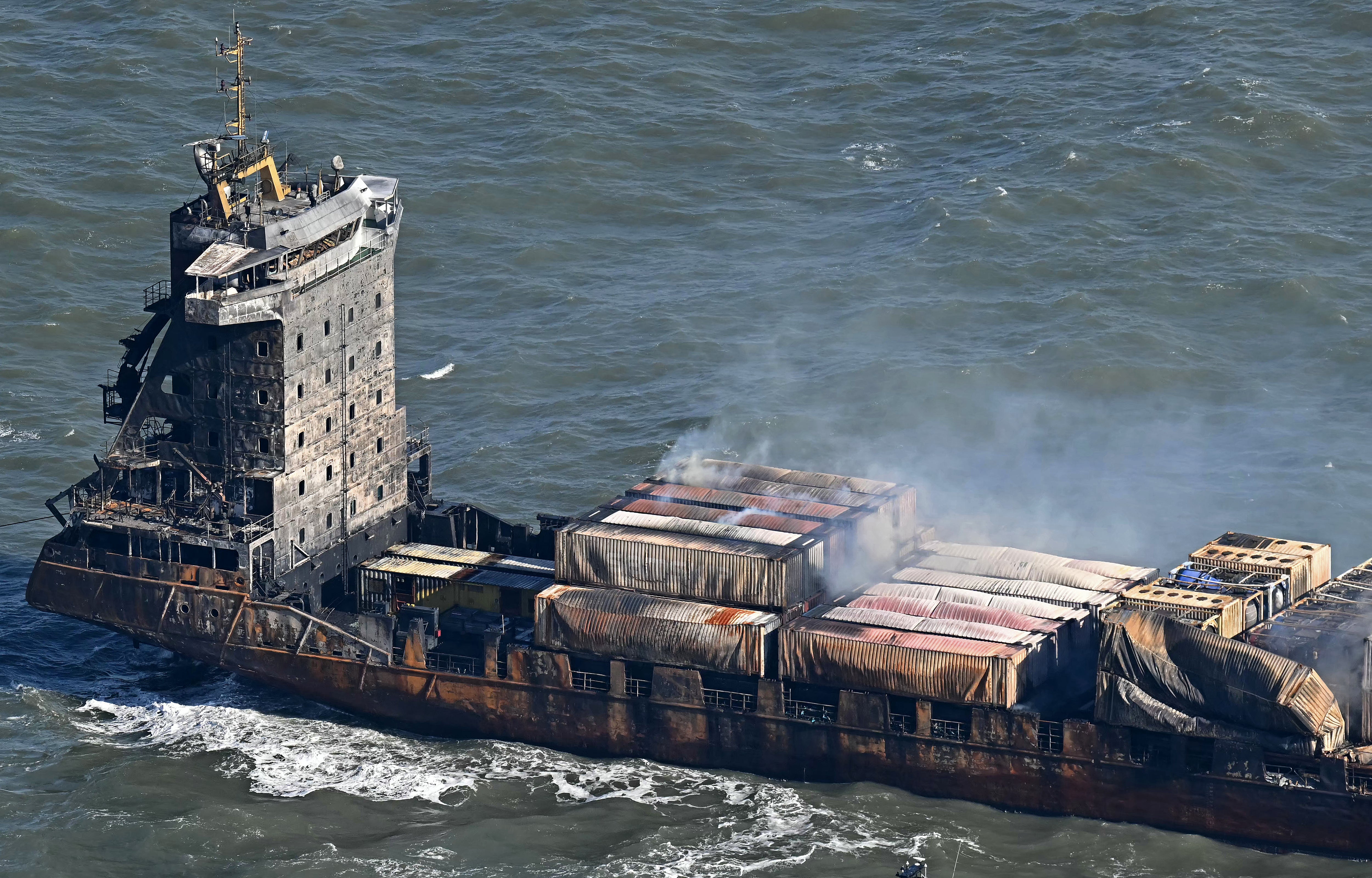 Smoke rises from damaged containers on the deck of the MV Solong cargo ship