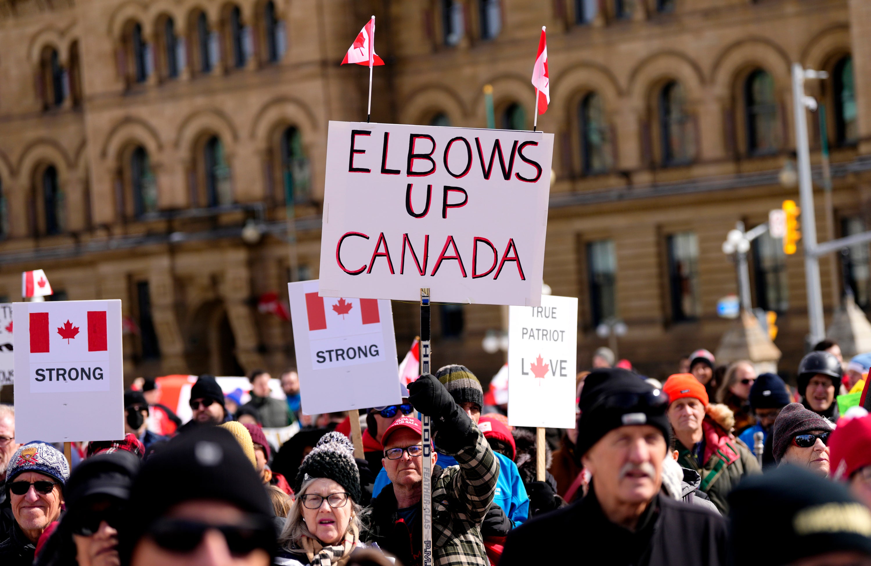 Rally-goer holds up “Elbows Up, Canada” sign at a protest against U.S. President Donald Trump's threats to Canadian sovereignty