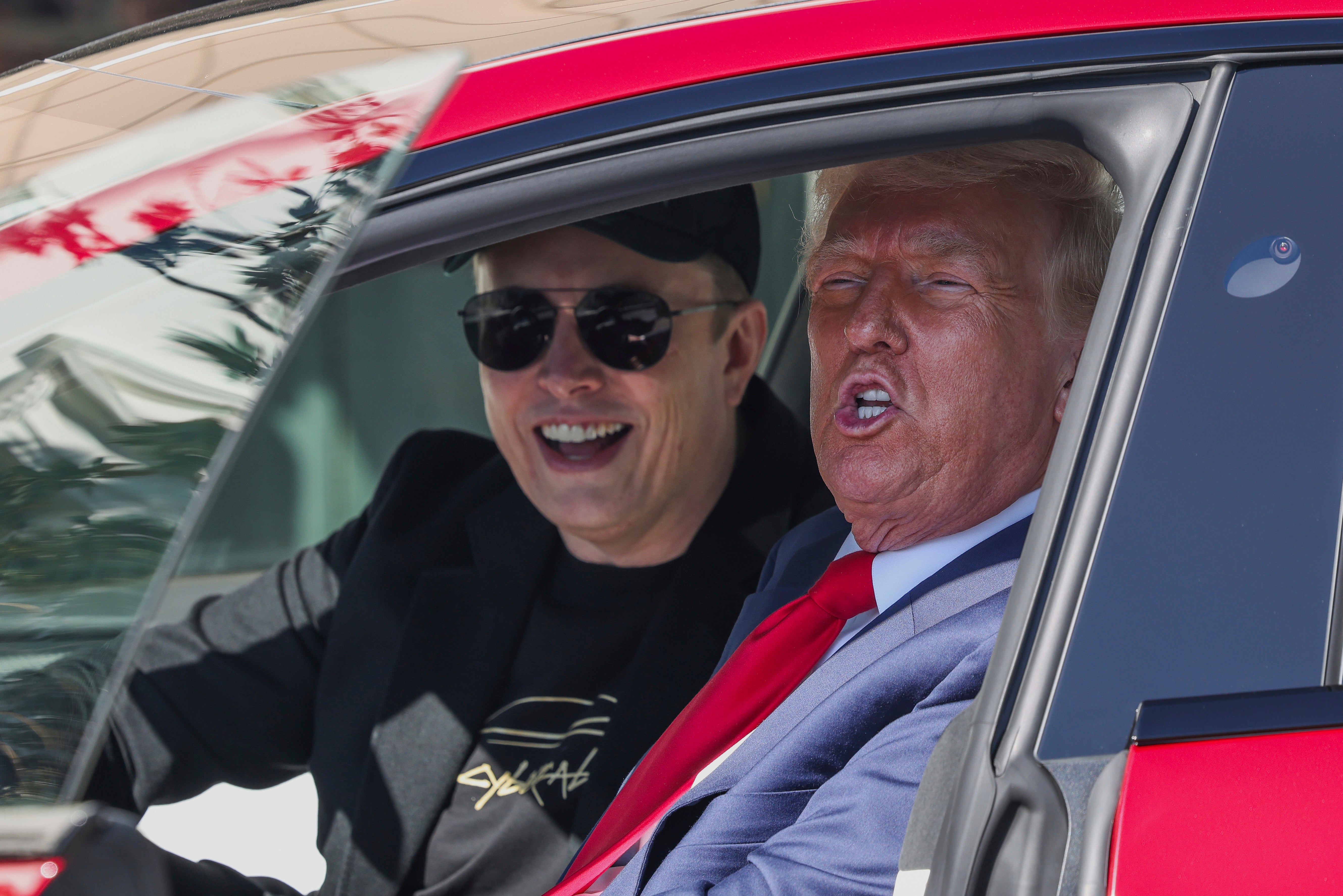 Donald Trump and Elon Musk speak to reporters as they sit in a red Model S Tesla vehicle on the south lawn of the White House (Pool via AP/PA)